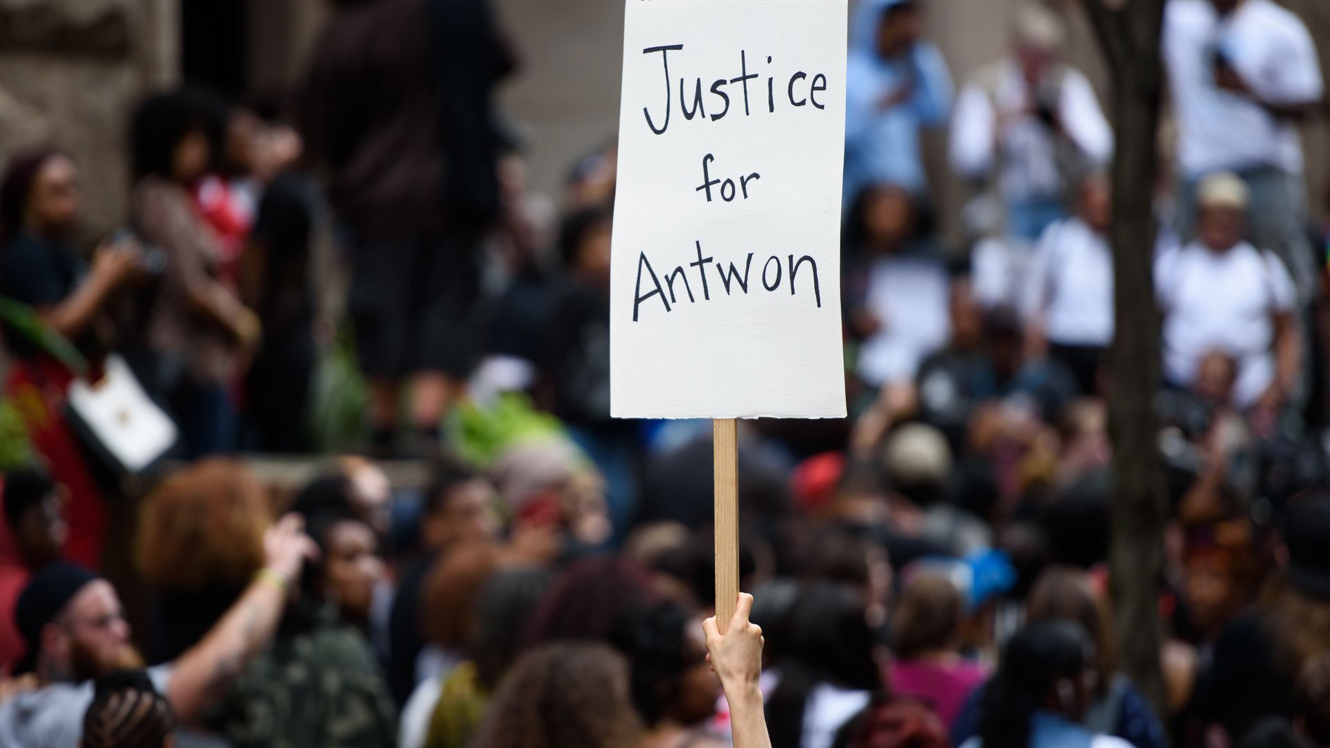 Protestors gather, holding a sign "Justice for Antwon"