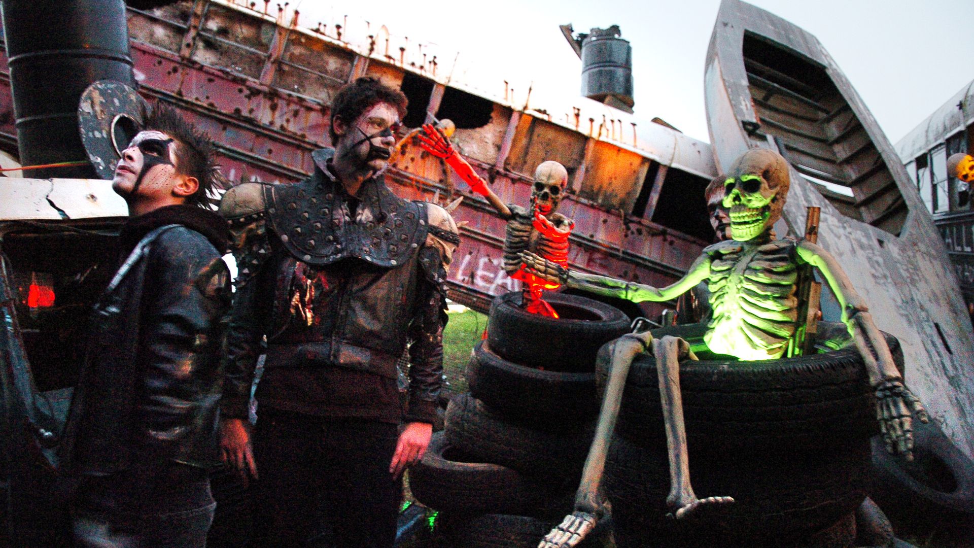 A glow-in-the-dark skeleton, crashed bus, and boy in a spooky black costume, all part of the scenery at Markoff's Haunted Forest in suburban Maryland.