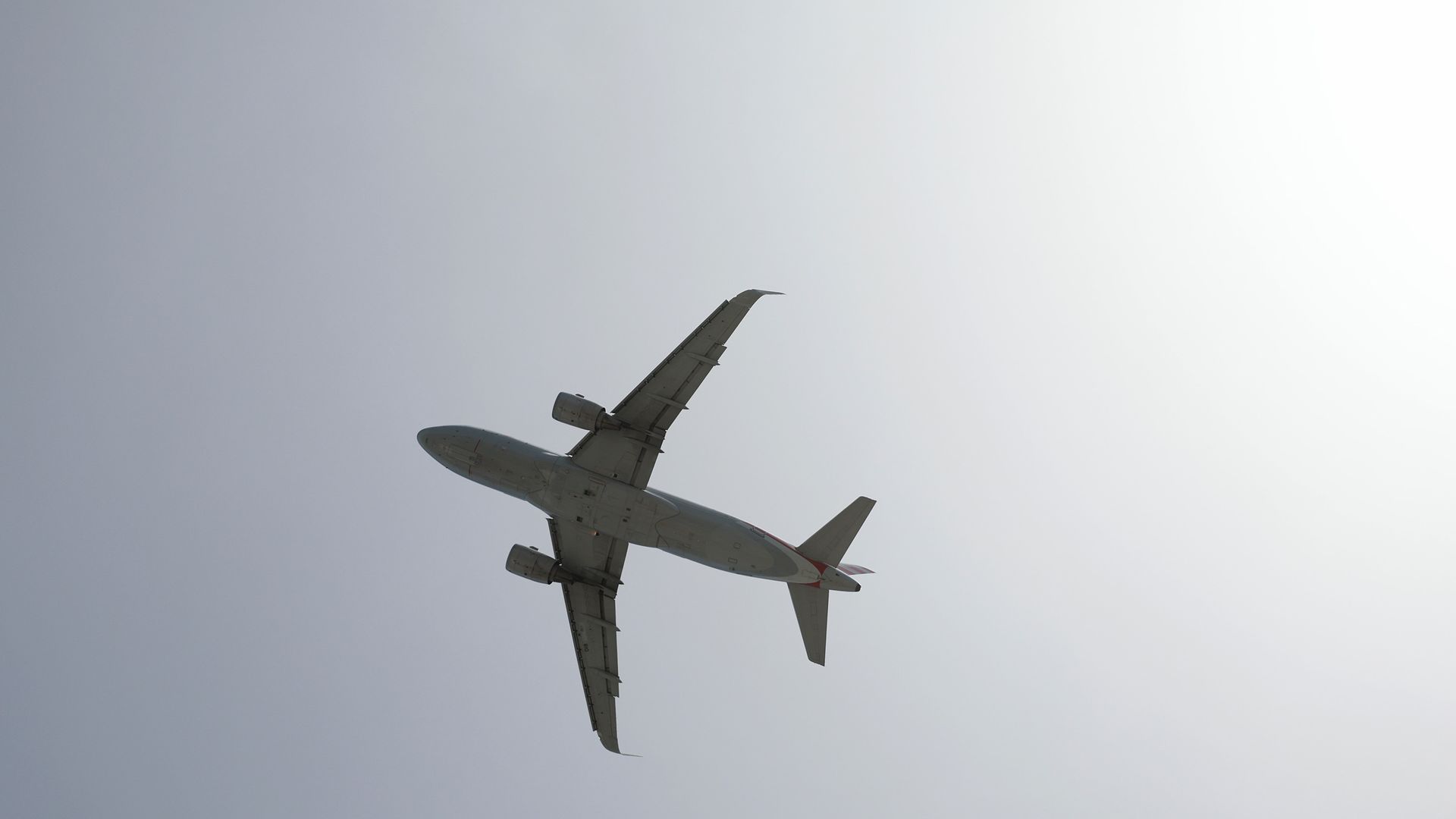 A plane is silhouetted against a grey/white sky 