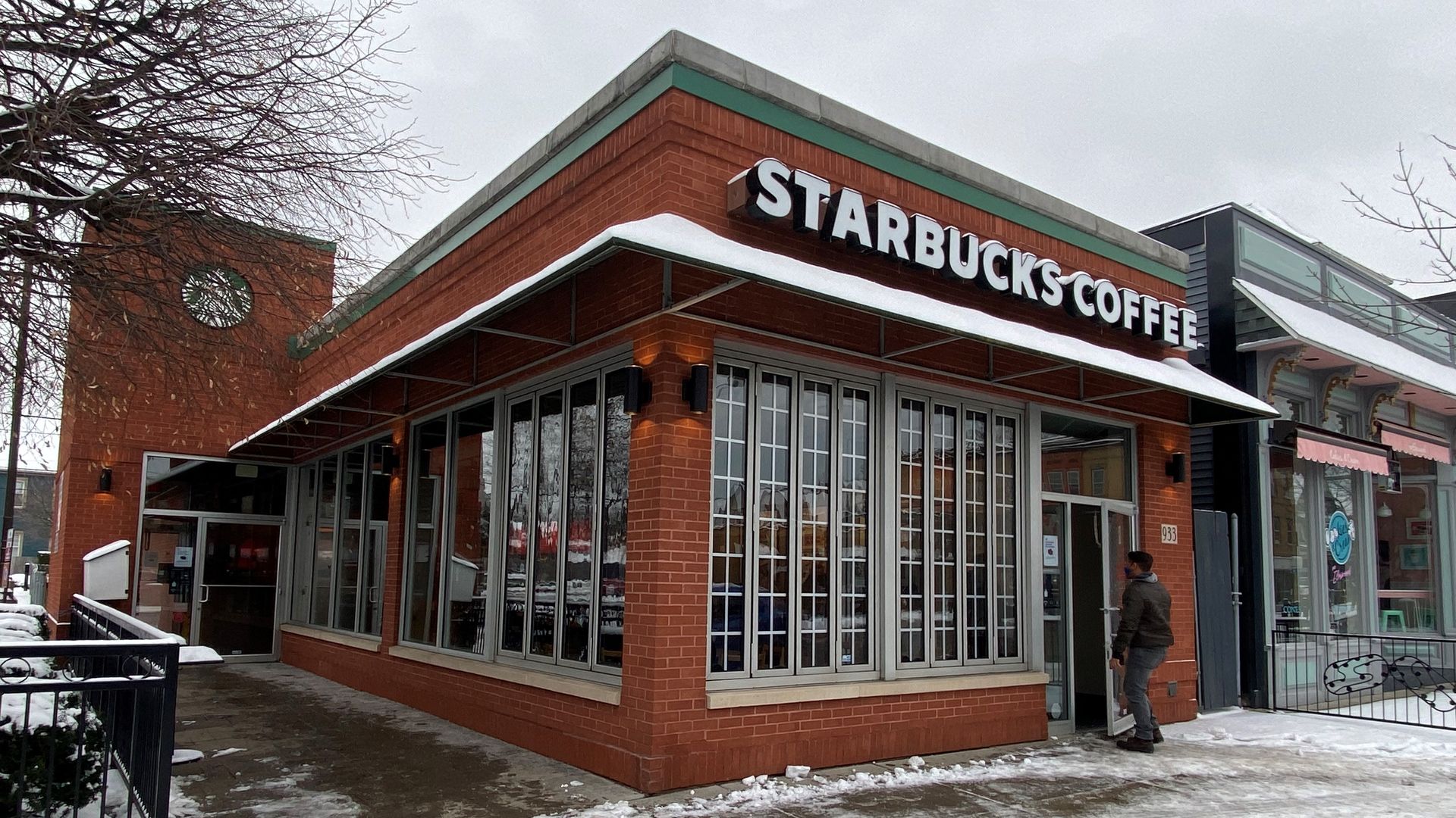Photo of a Starbucks store built from red brick, with snow on the ground