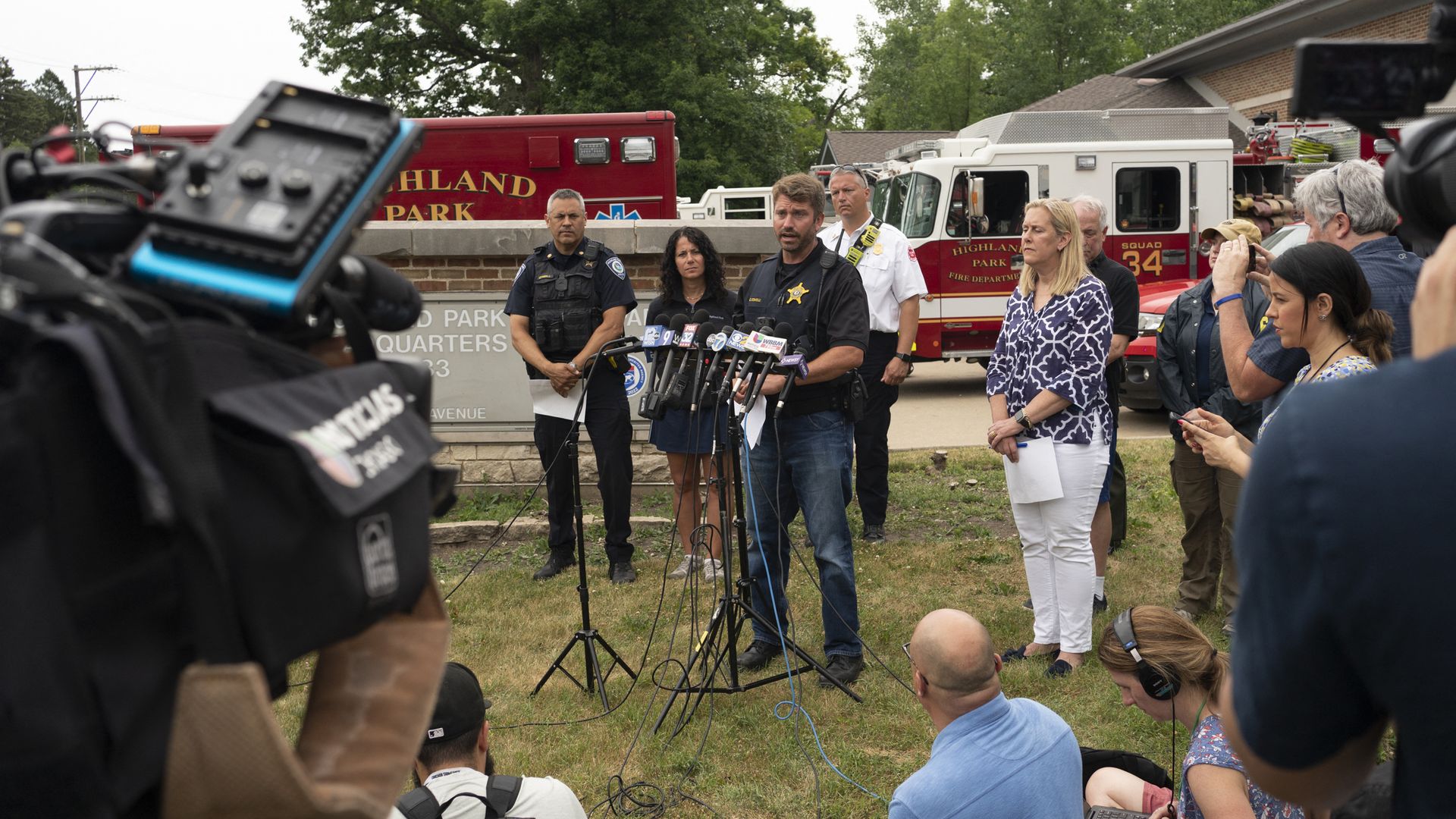 Photo of a press conference on a lawn. 
