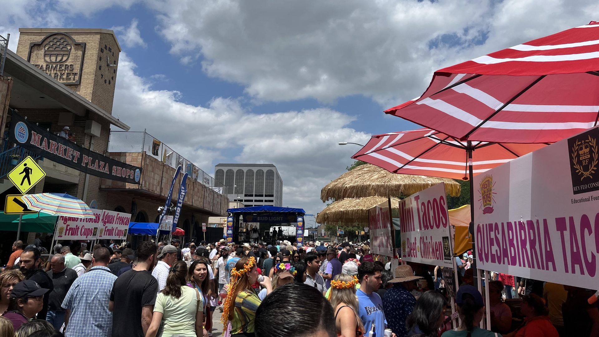 A cloudy blue sky over last year's Fiesta event in Market Square, with signs for mini tacos.