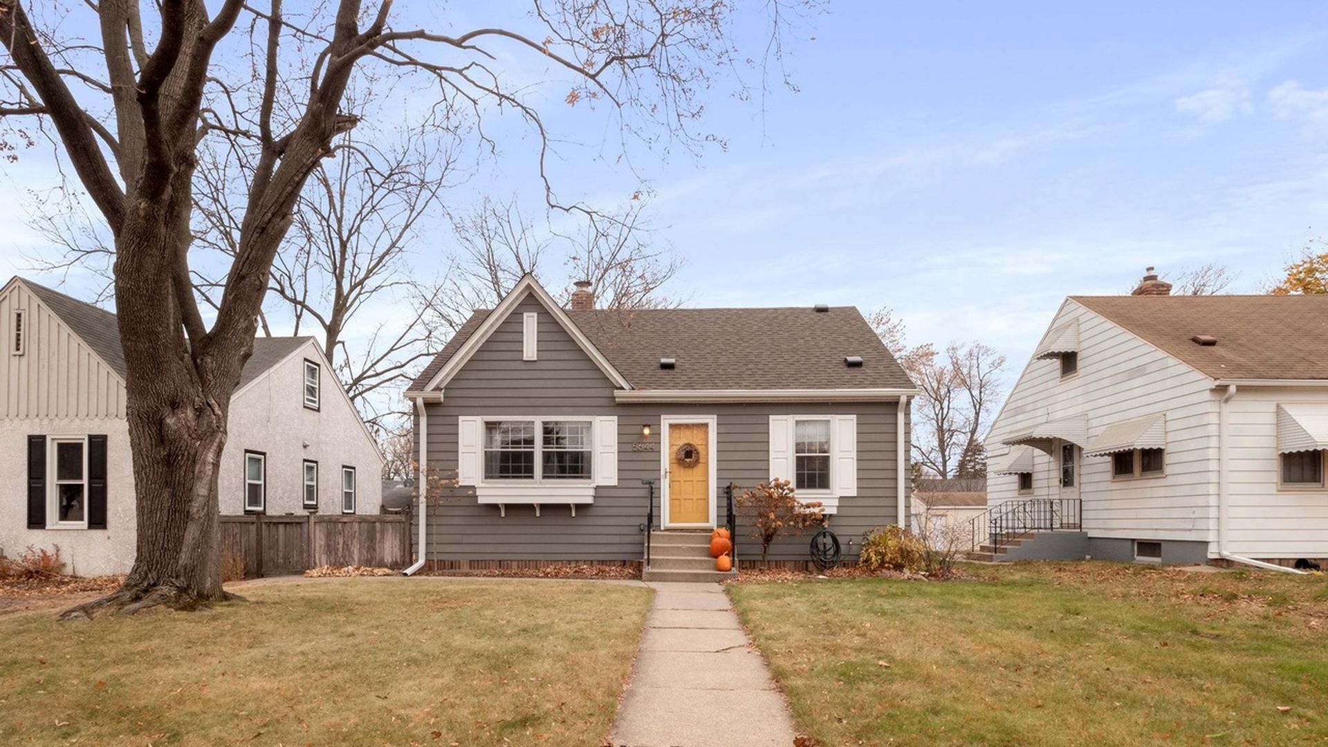 exterior of dark home with orange front door