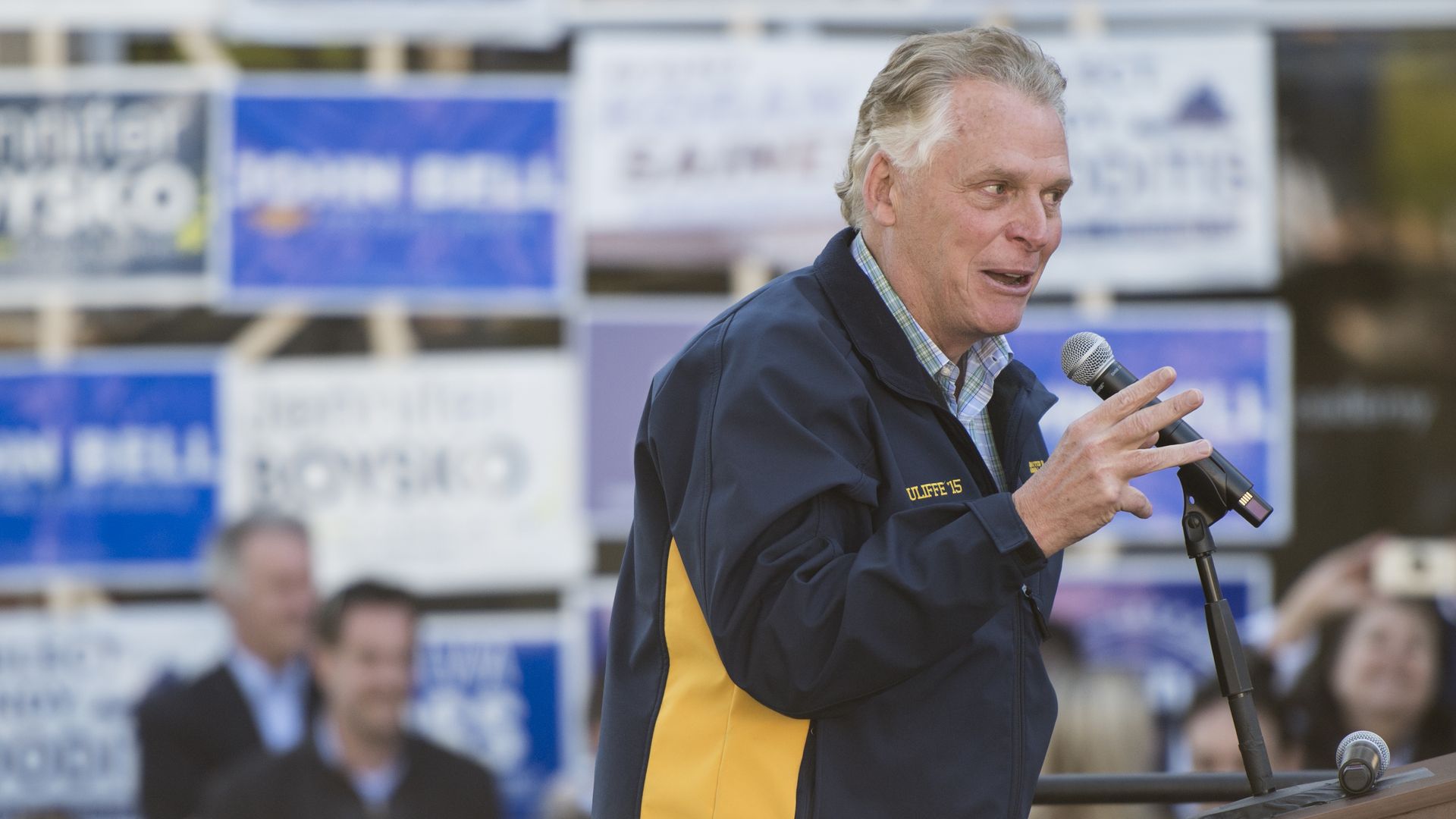 Terry McAuliffe is seen on a stage.