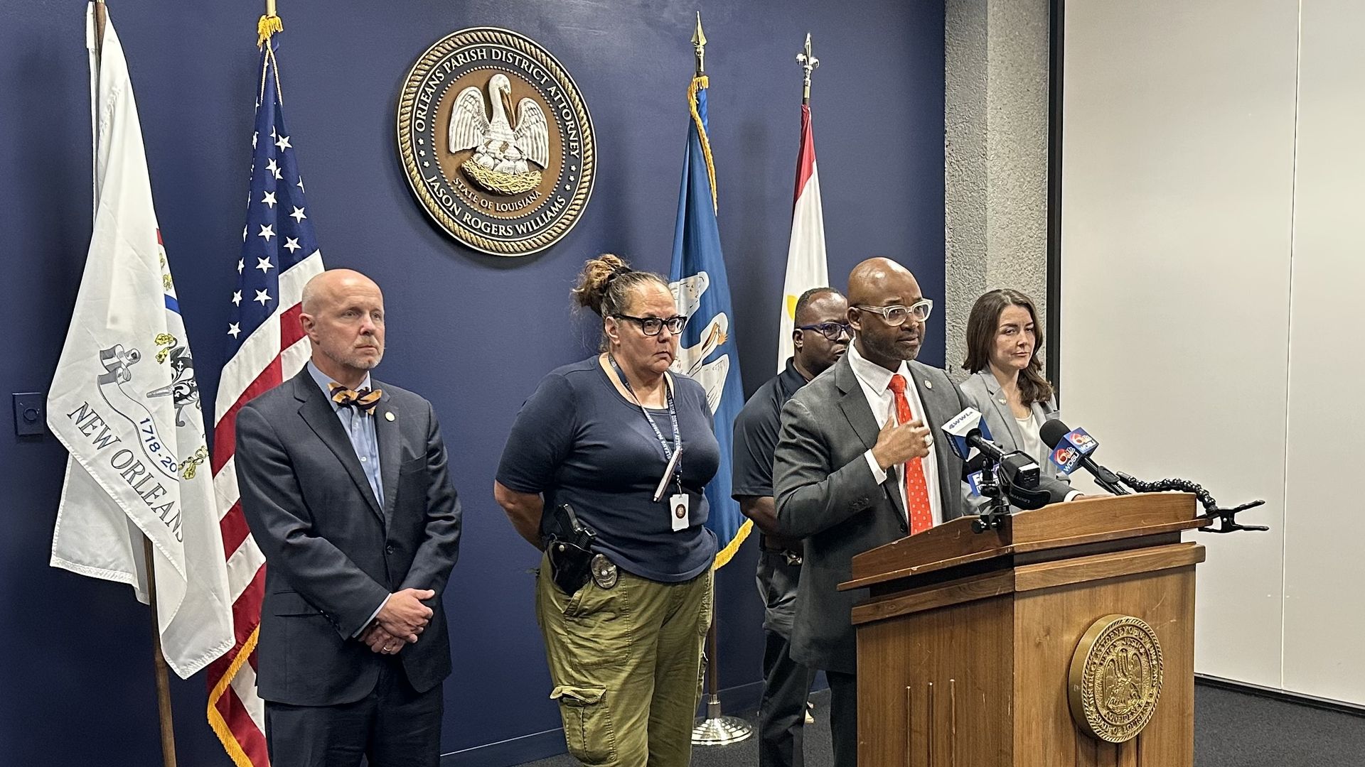 Jason Williams stands a podium with four people standing behind him.