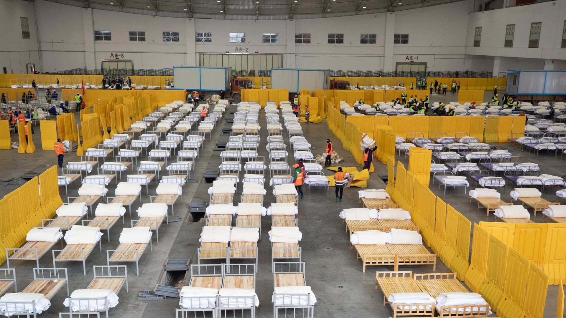 In February, with cases rising rapidly, workers set up a makeshift hospital in a Wuhan exhibition center. Photo: Costfoto/Barcroft Media via Getty Images