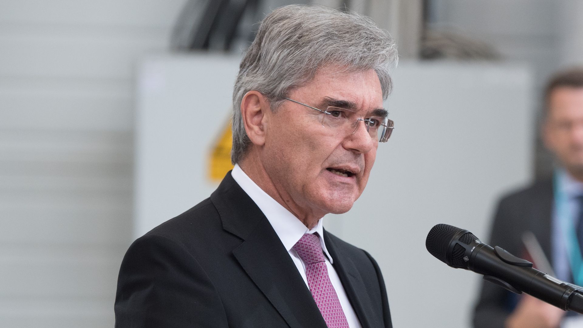 Siemens CEO speaking into a microphone. 