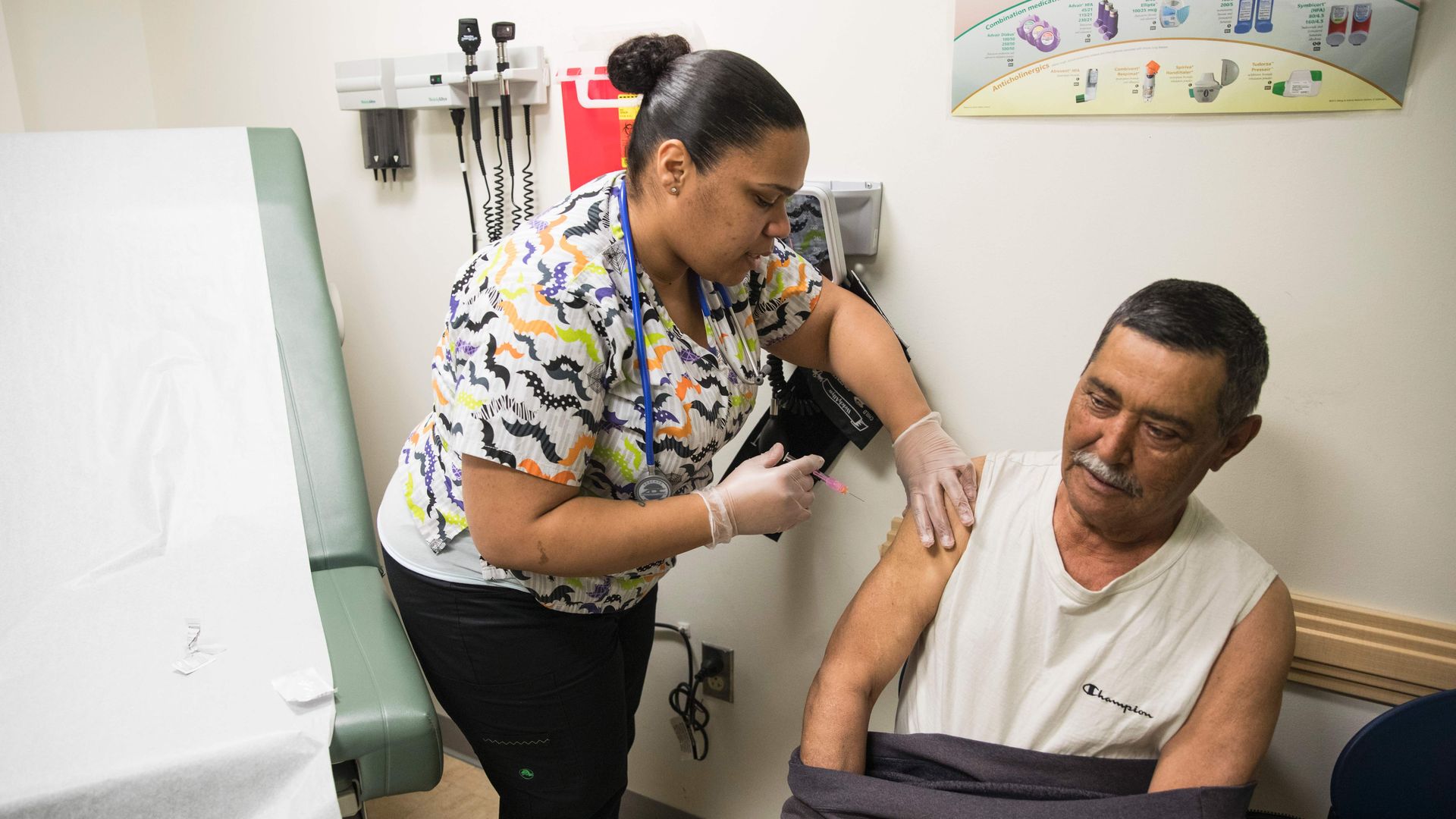 A nurse assistant treats a patient in a health center office.