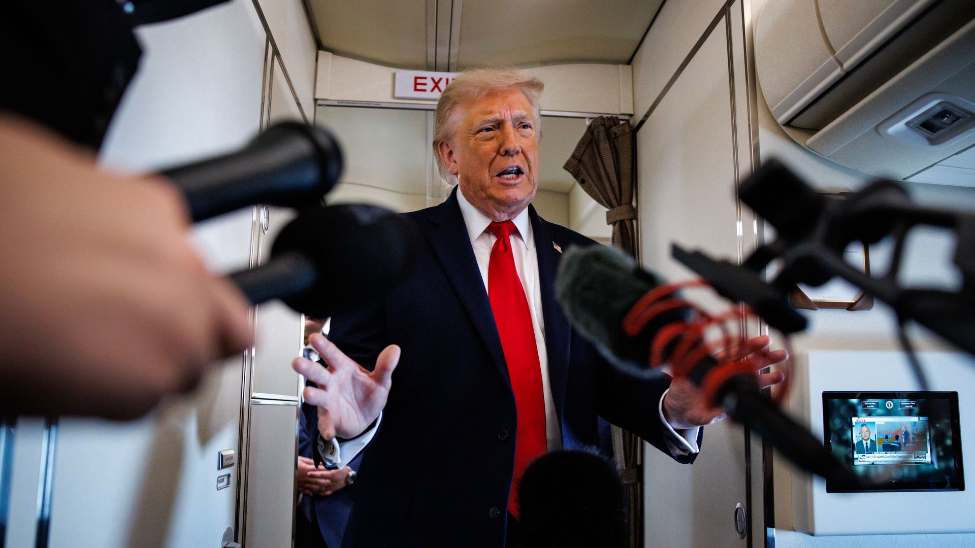 Trump answers reporters questions as they extend mics toward him