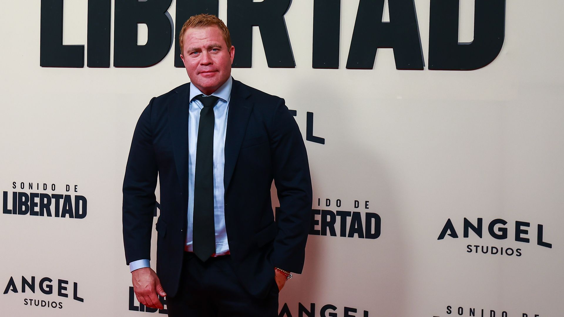 Tim Ballard stands in front of a promotional screen that reads "Sonido de Libertad"