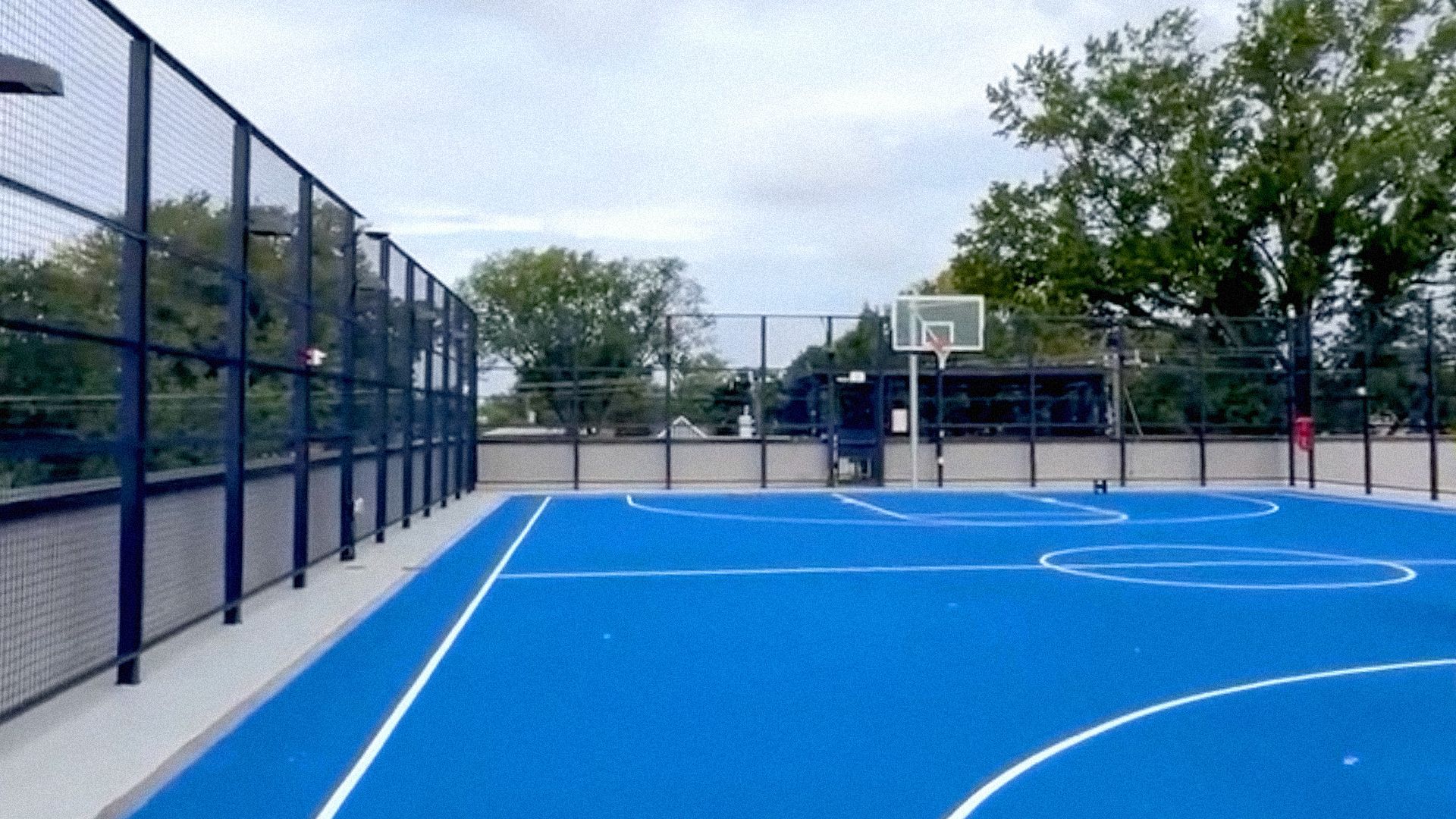 A bright blue rooftop bball court 