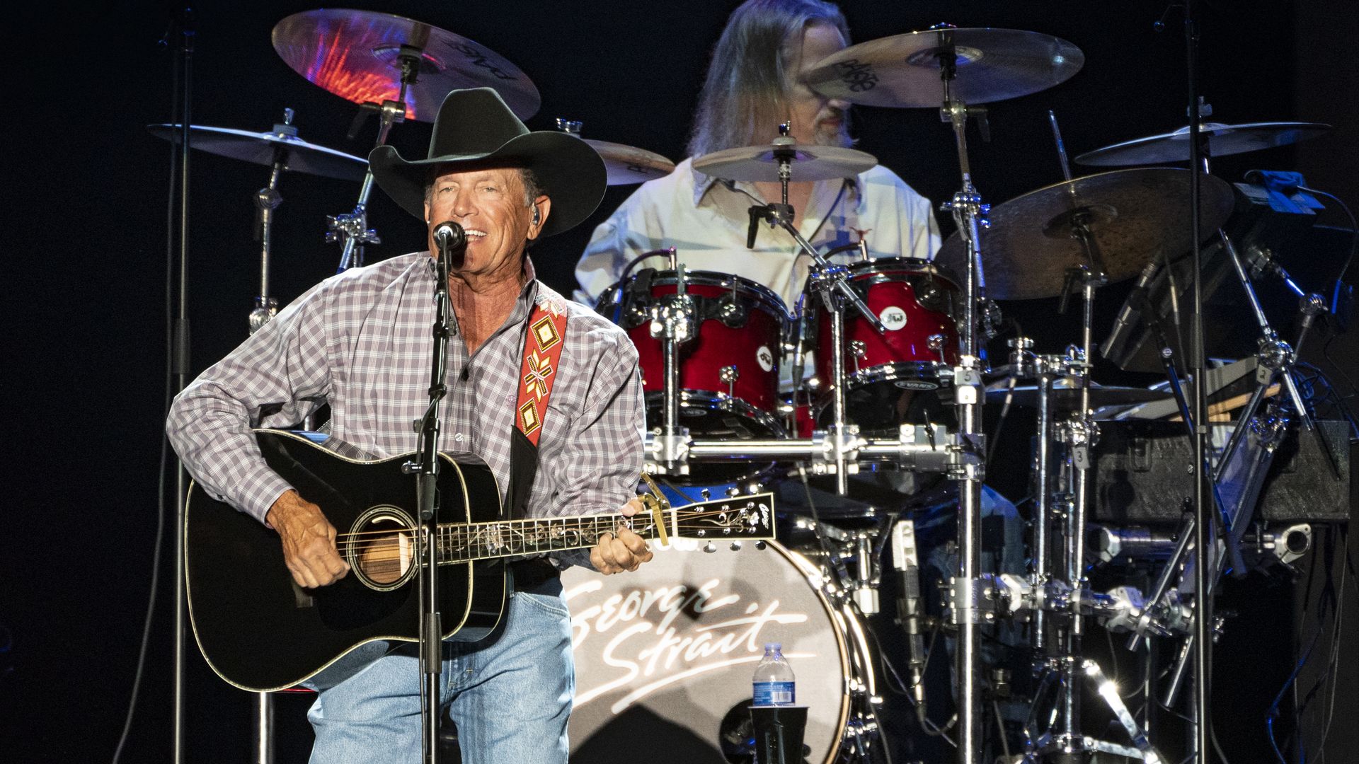 George Strait singing with a guitar in hand