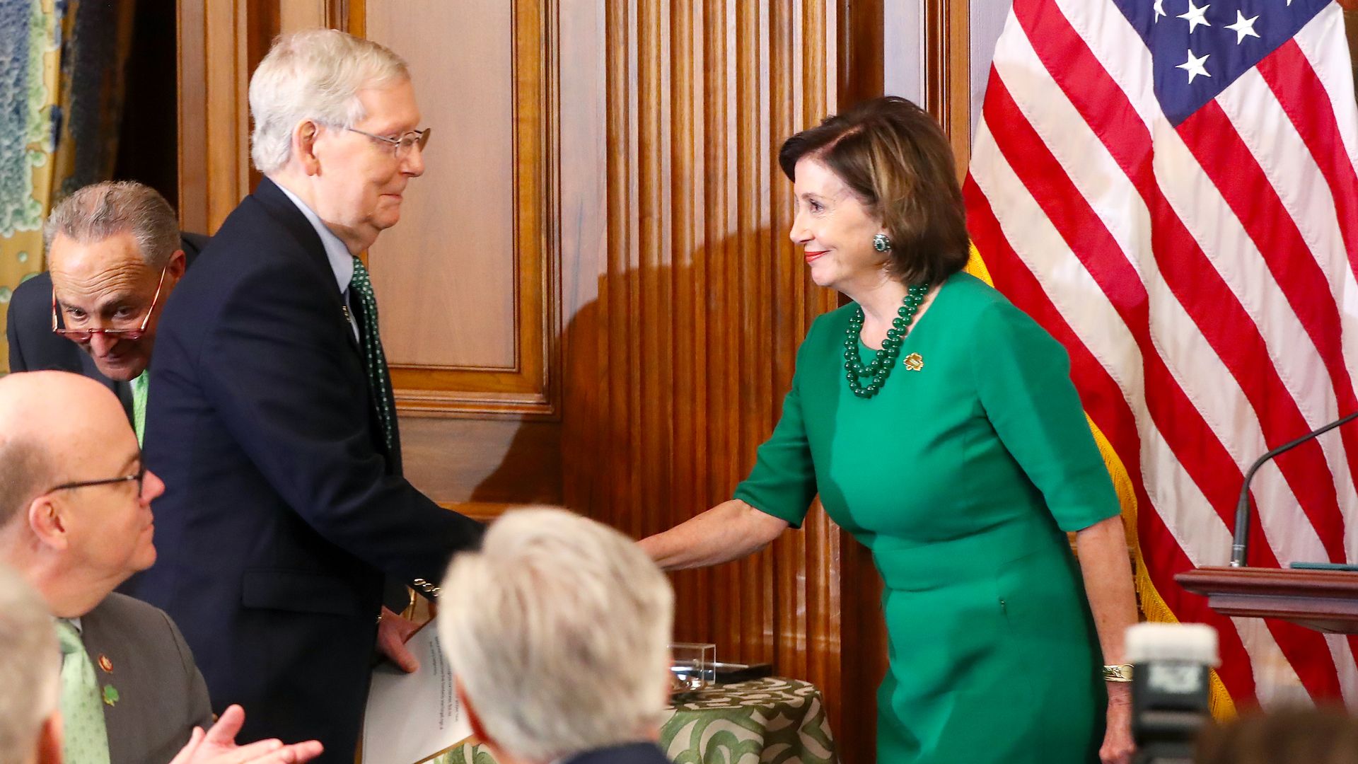 In this image, Pelosi and McCOnnell shake hands