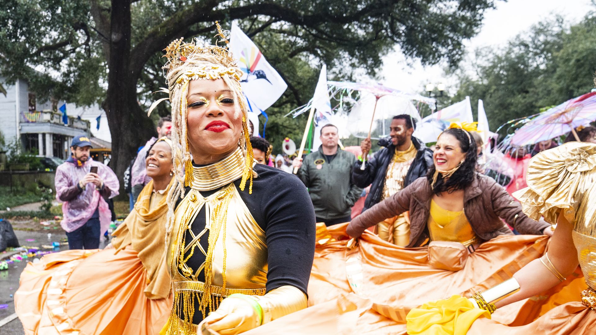 women dressed in gold-colored gowns during a parade