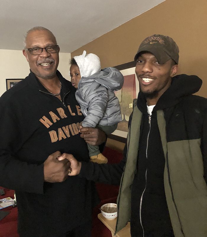 Michael Smith (left) stands next to his son, Sam, while holding Sam's son, Noah (courtesy of Silvia Smith) 