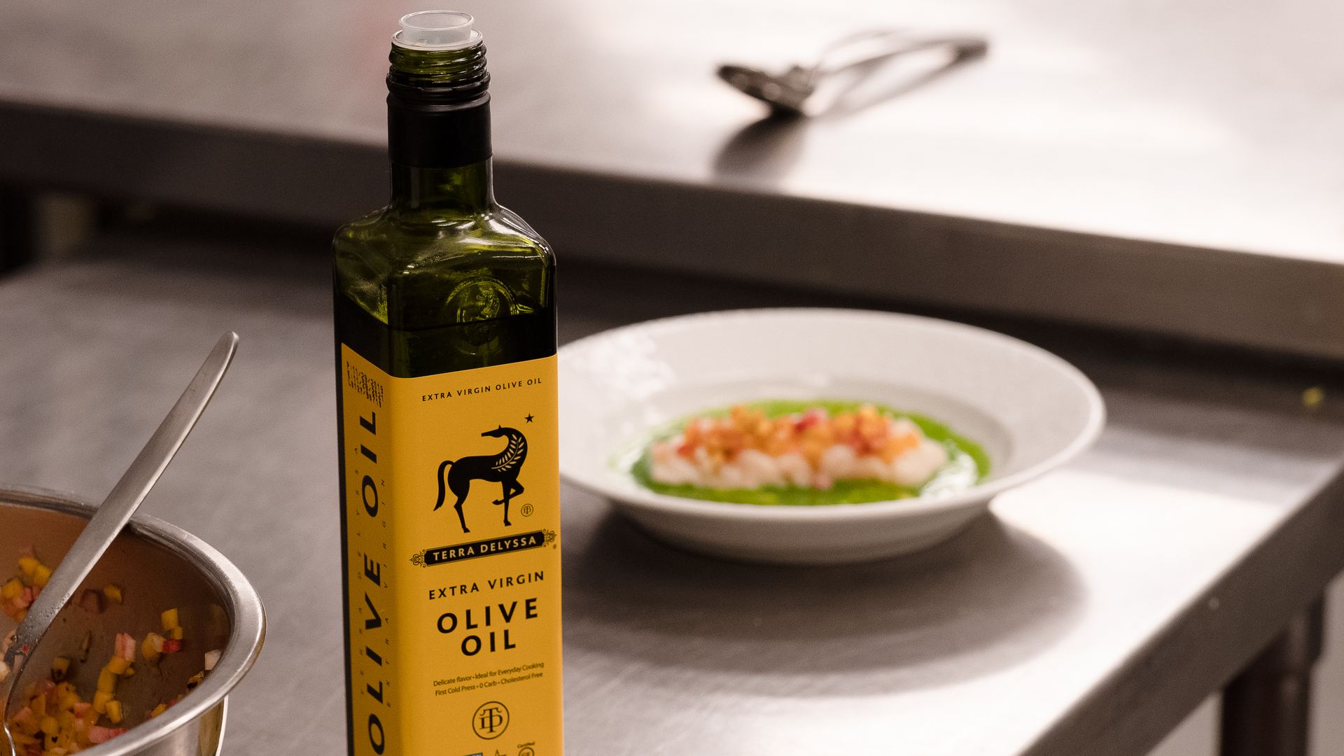 An image of an olive oil bottle next to a plate of food