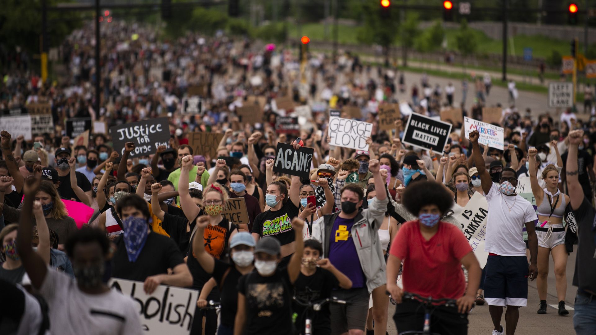A large crowd marches down a street