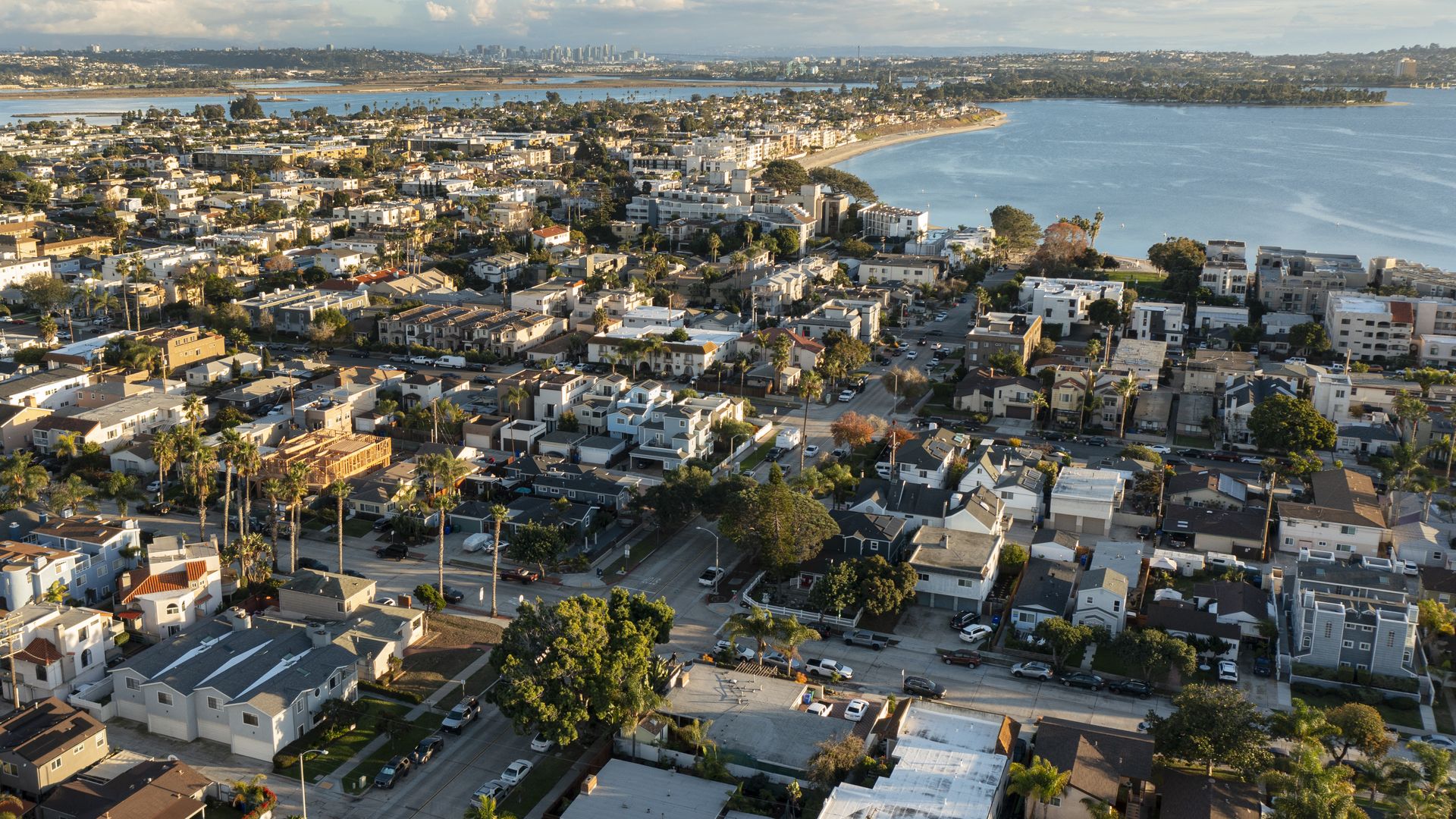 An aerial view of condominiums, apartments and single family homes near the water.