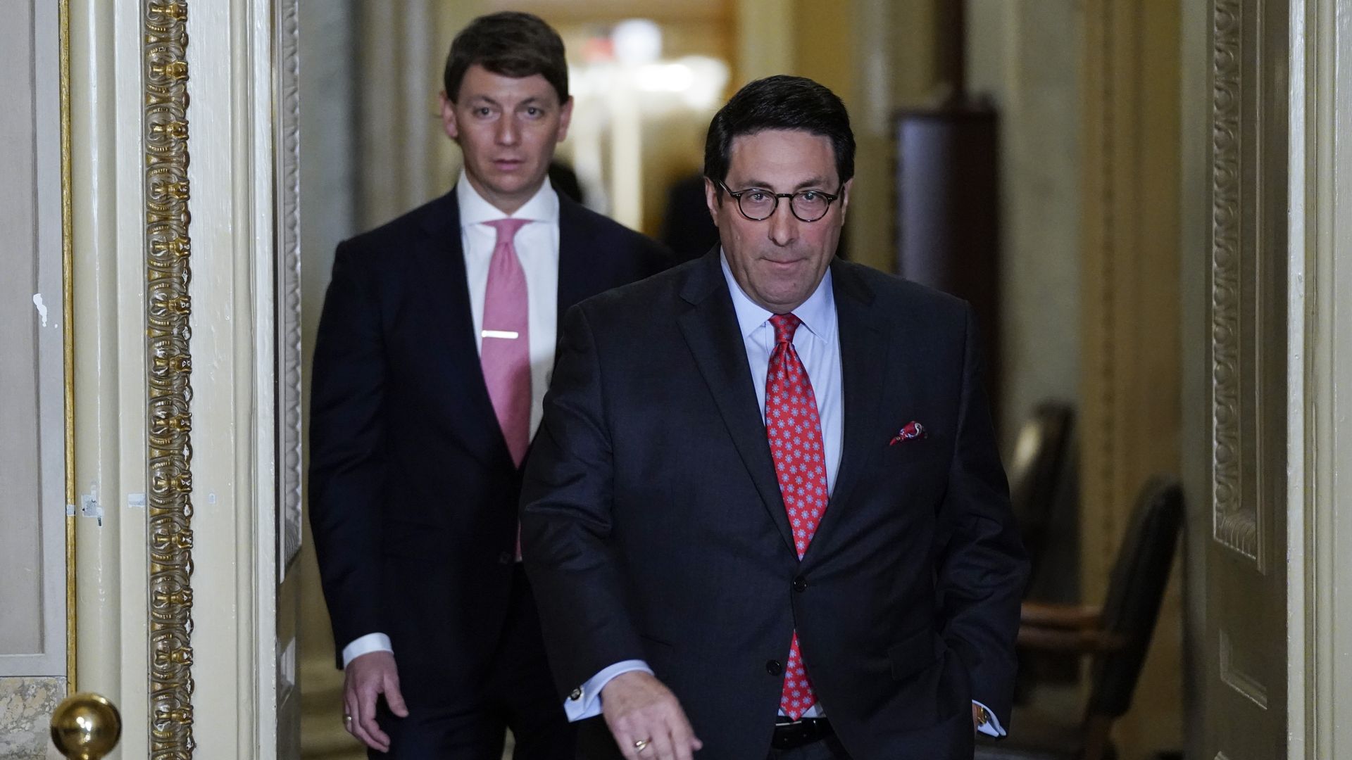 White House Deputy Press Secretary Hogan Gidley walks behind Trump's personal lawyer Jay Sekulow in the Capitol on Thursday evening at Trump's impeachment trial.
