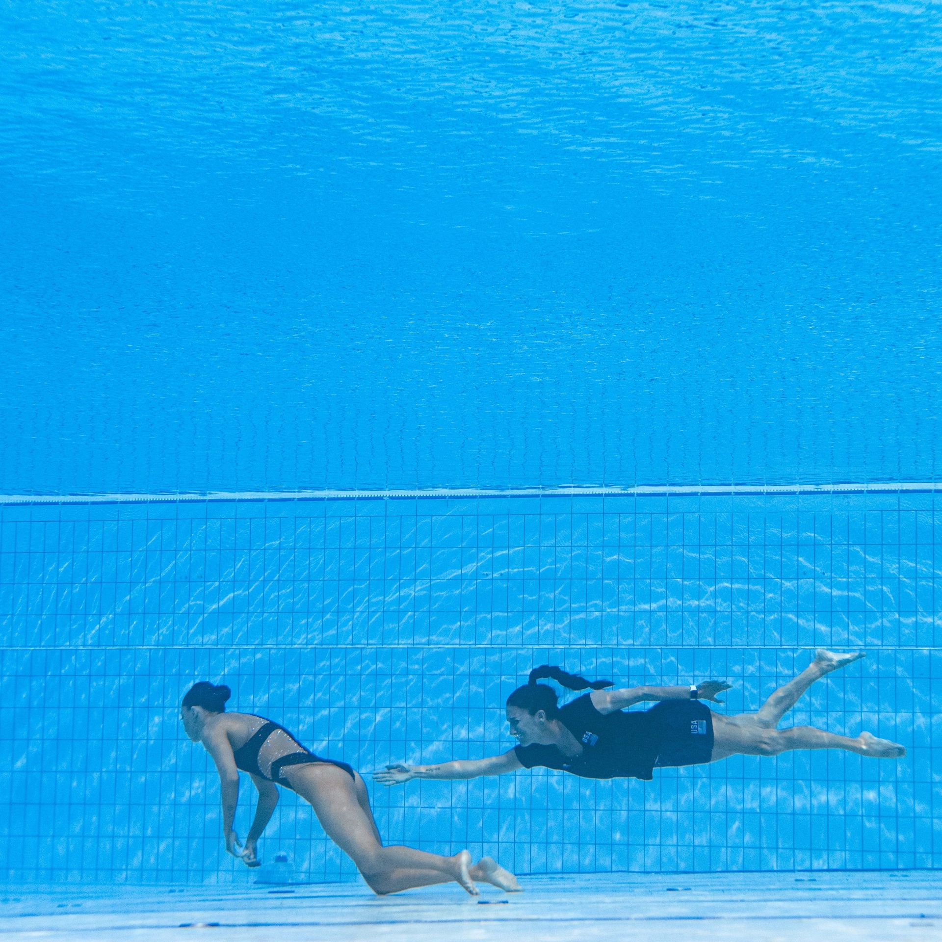 Fuentes swimming toward Alvarez as she sank to the bottom of the pool. 