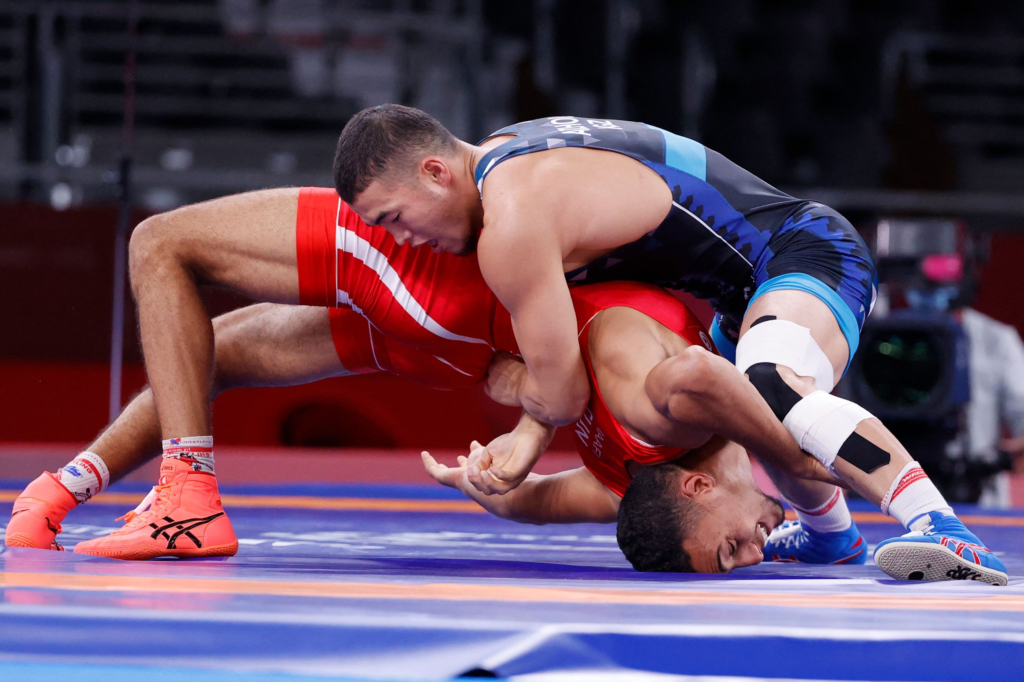 Kyrgyzstan's Akzhol Makhmudov (blue) wrestles Tunisia's Lamjed Maafi in their men's greco-roman 77kg wrestling early round match during the Tokyo 2020 Olympic Games on August 2