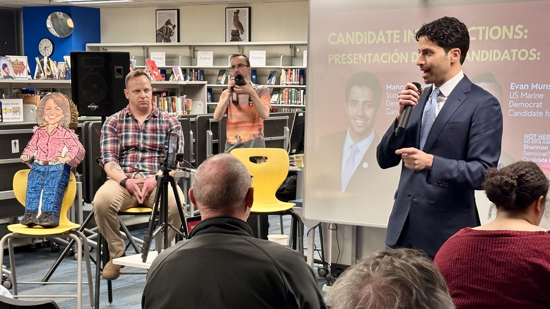 State Rep. Manny Rutinel, right, addresses an 8th District campaign forum Tuesday at Thornton High School in front of rival Evan Munsing, middle, and a piñata of the candidate Shannon Bird. Photo: John Frank/Axios