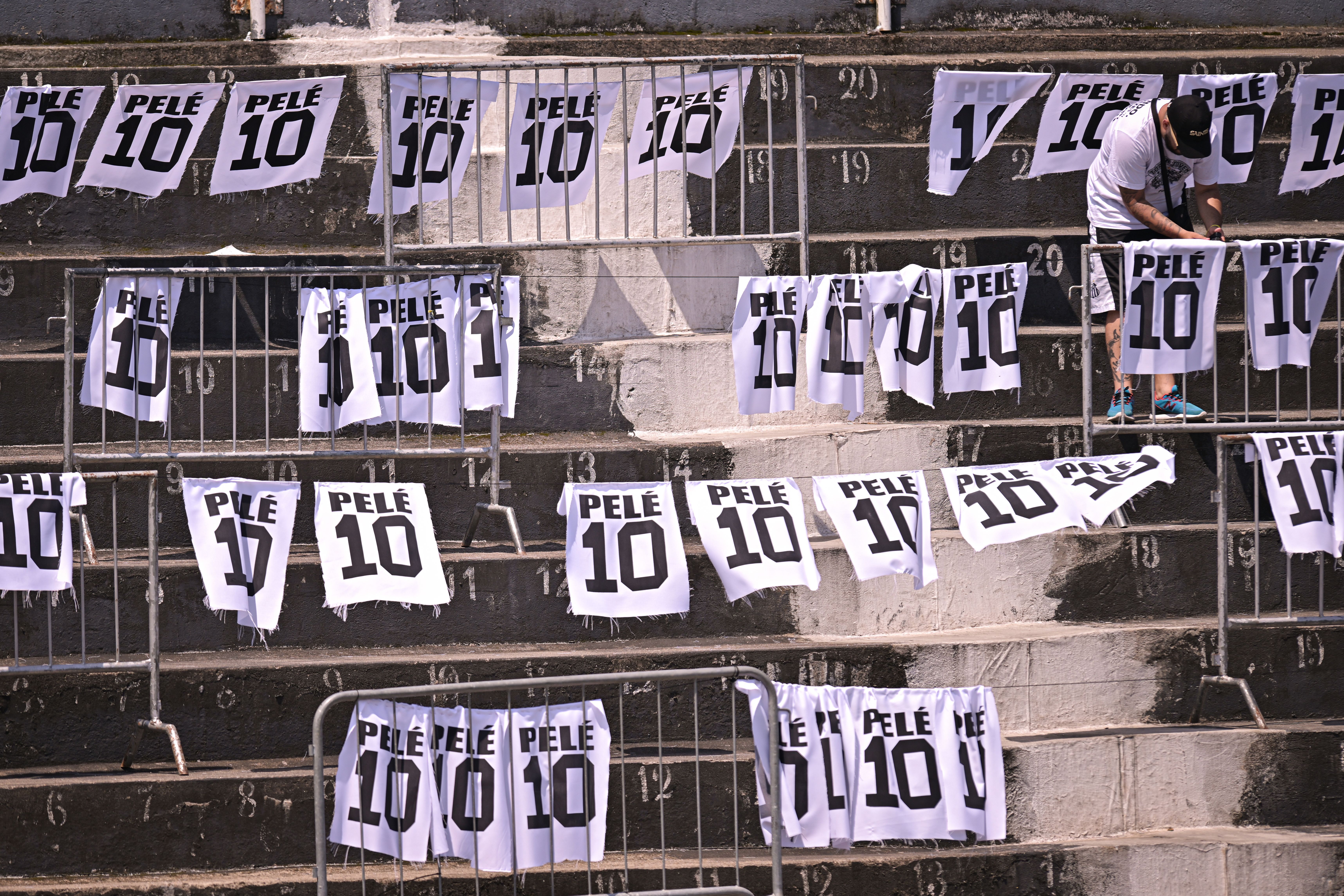 A mourner places banners on the Vila Belmiro stadium stands during Pelé's funeral on January 02, 2023 in Santos, Brazil