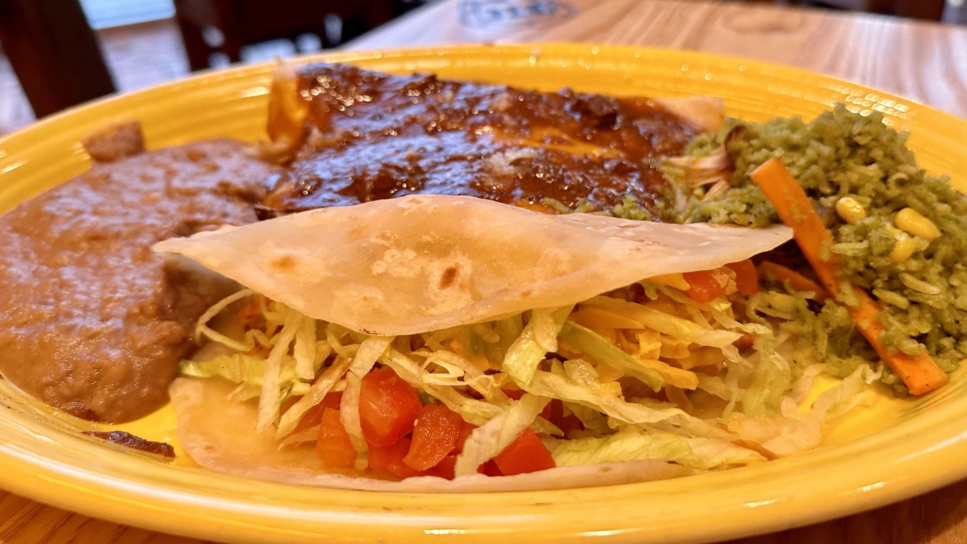 A photo of a plate of tacos and enchiladas