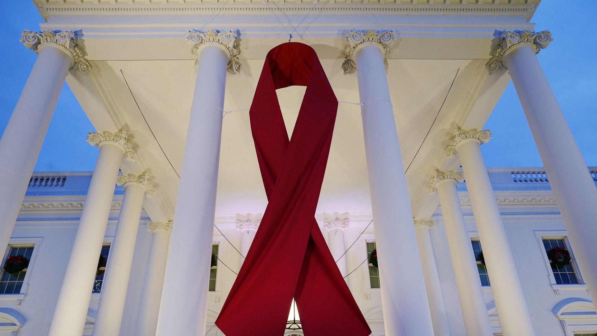 Photo of a giant red ribbon hanging at the front of the White House