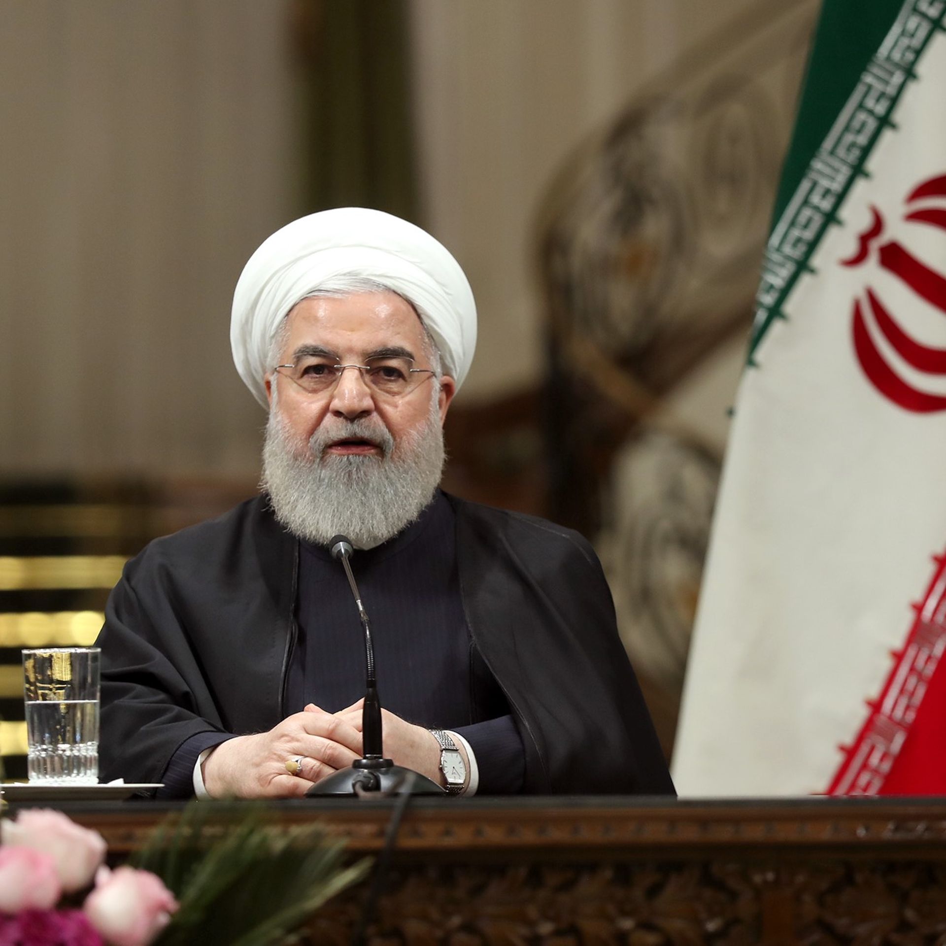 Hassan Rouhani seated at a press conference