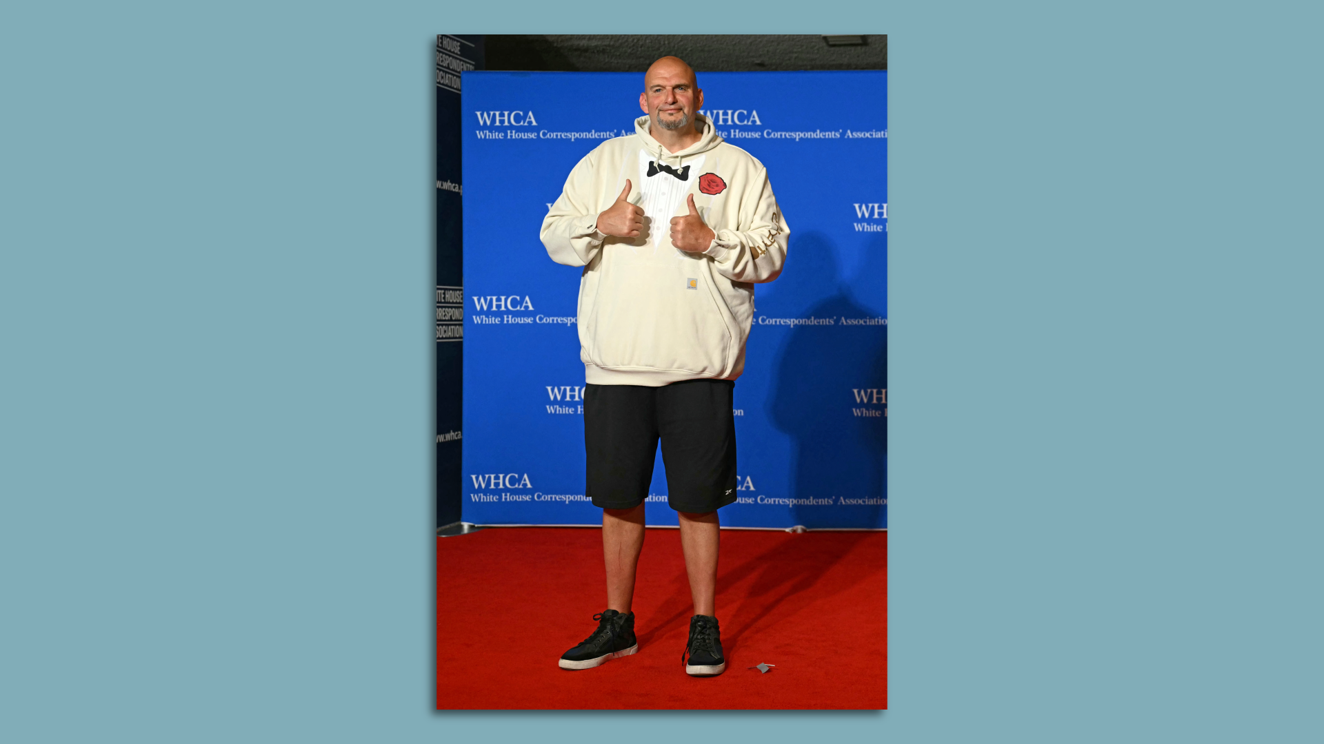 Sen. John Fetterman wears black shorts and a sweatshirt with a bowtie on it.