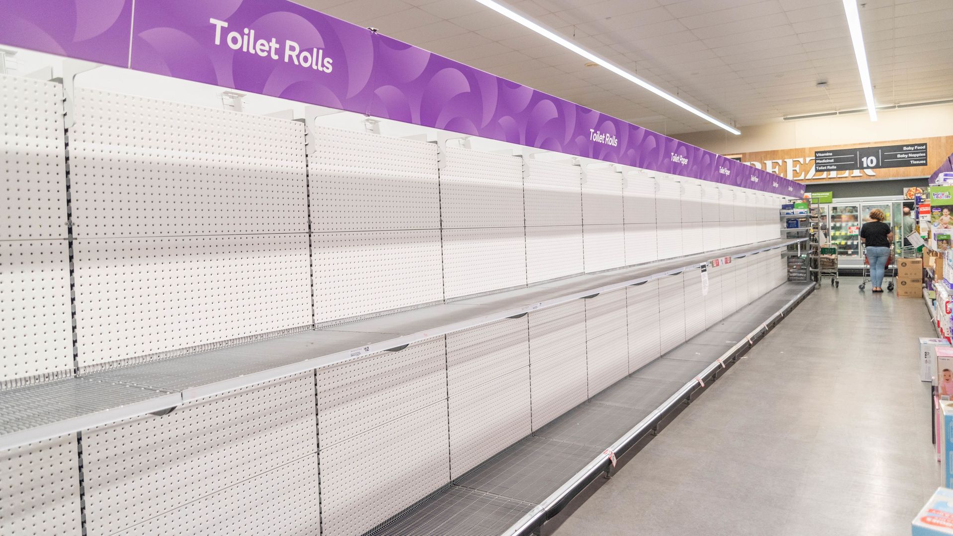 Empty supermarket shelves that formerly held toilet paper