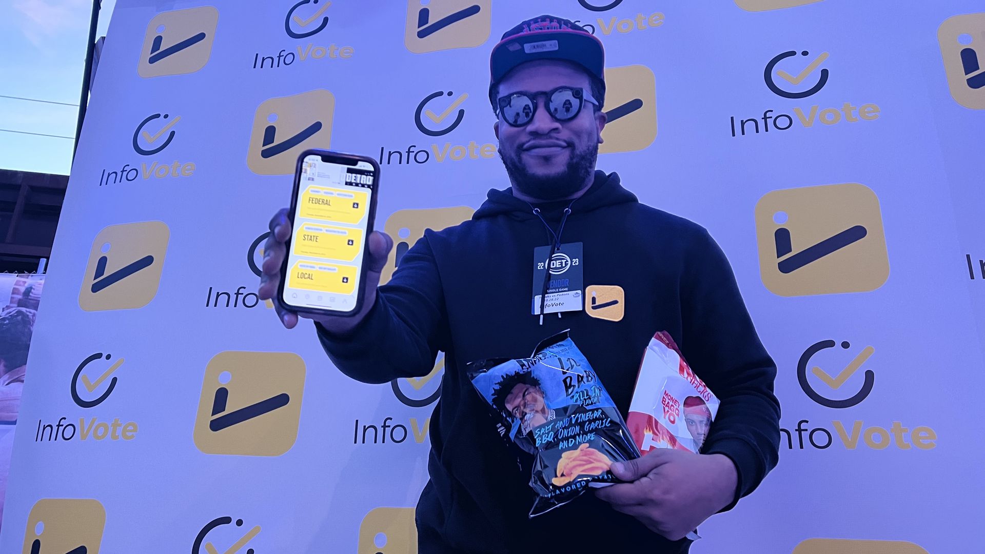 Myron Ragsdale holds his app he created in one hand and the Rap Snacks which contain a link to the app on the back. 
