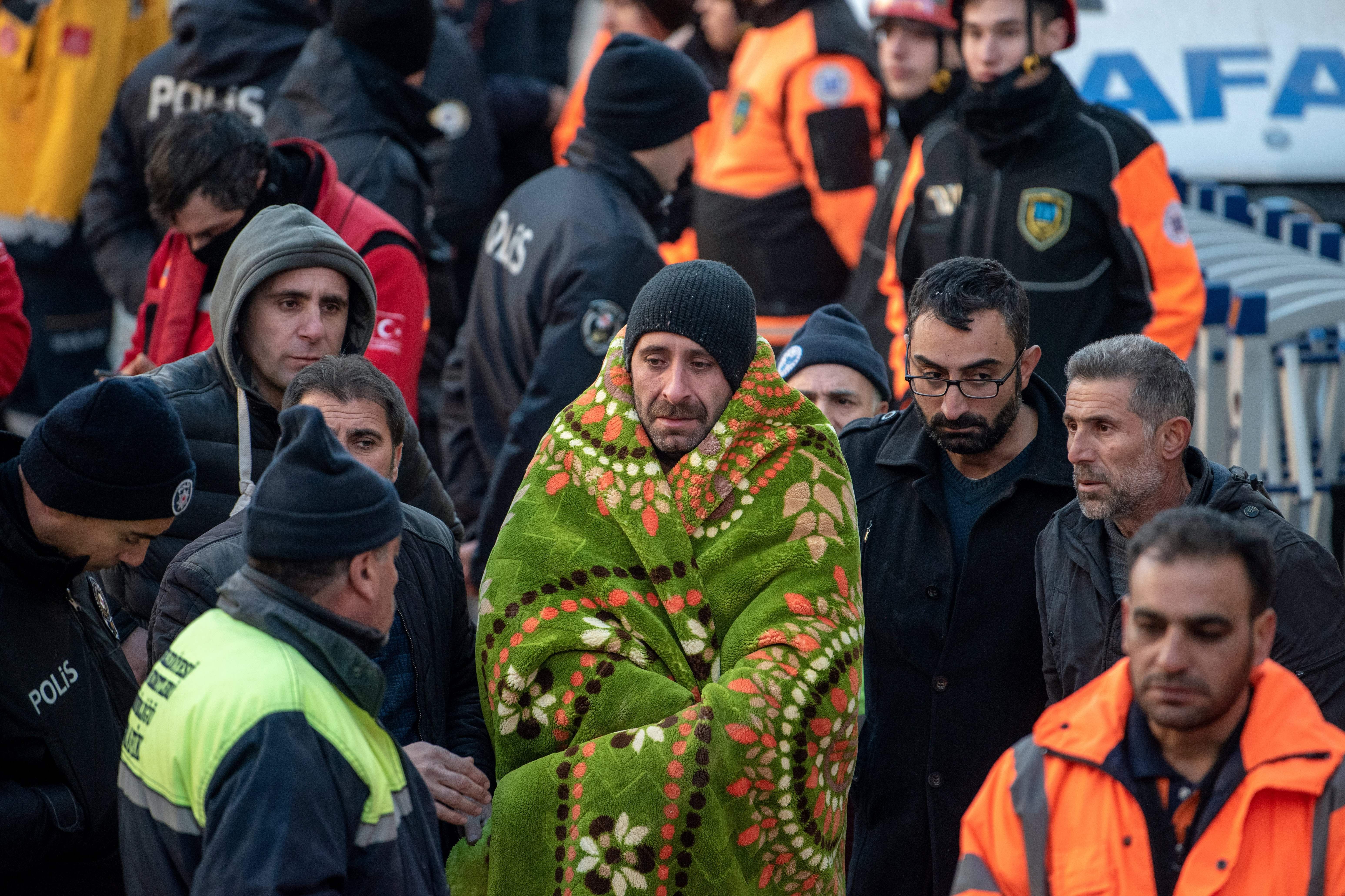 A man waits for his relative to be saved after an earthquake in Elazig, eastern Turkey