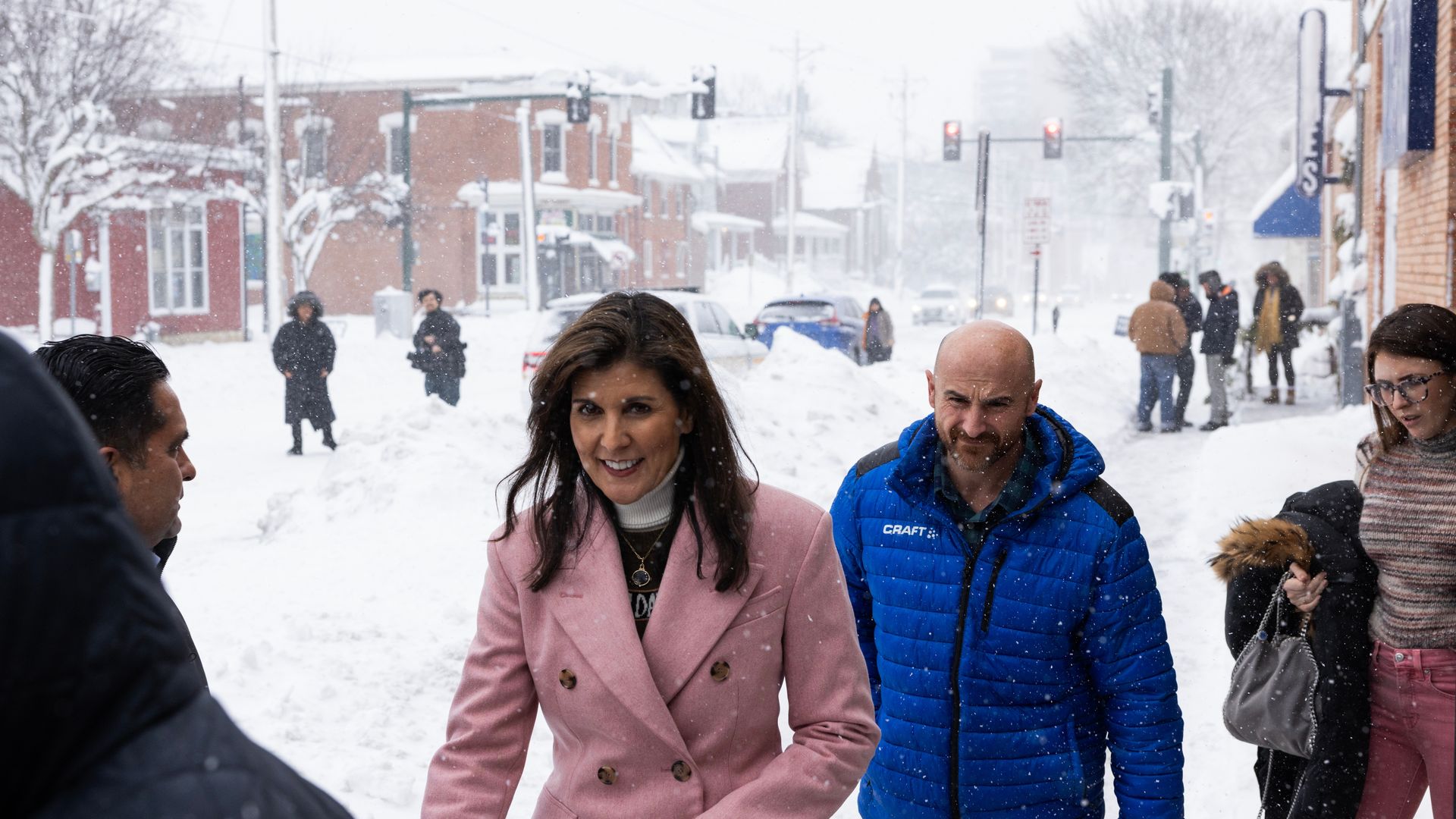 Nikki Haley campaigns in the snow wearing a pink coat.