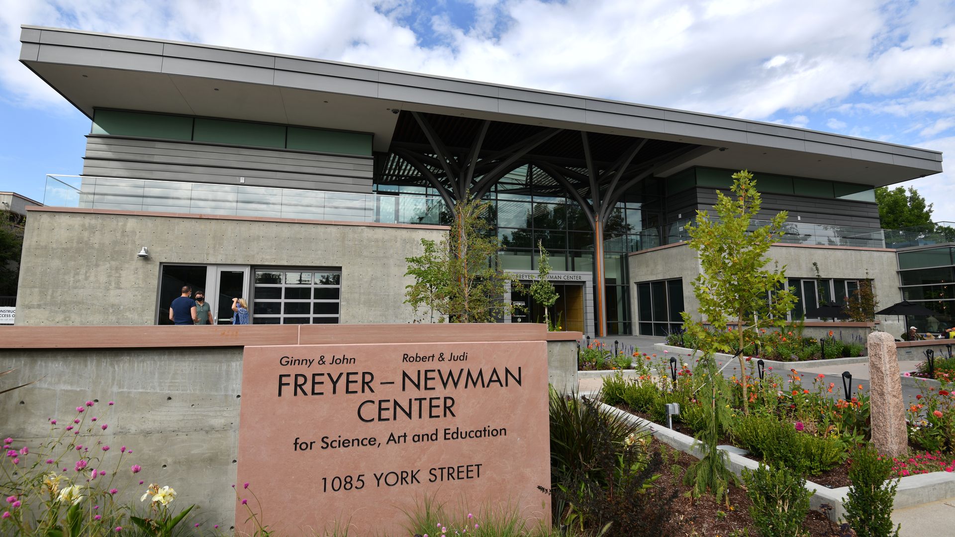 A building with the words FRYER NEWMAN CENTER in a stone block surrounded by shrubbery.