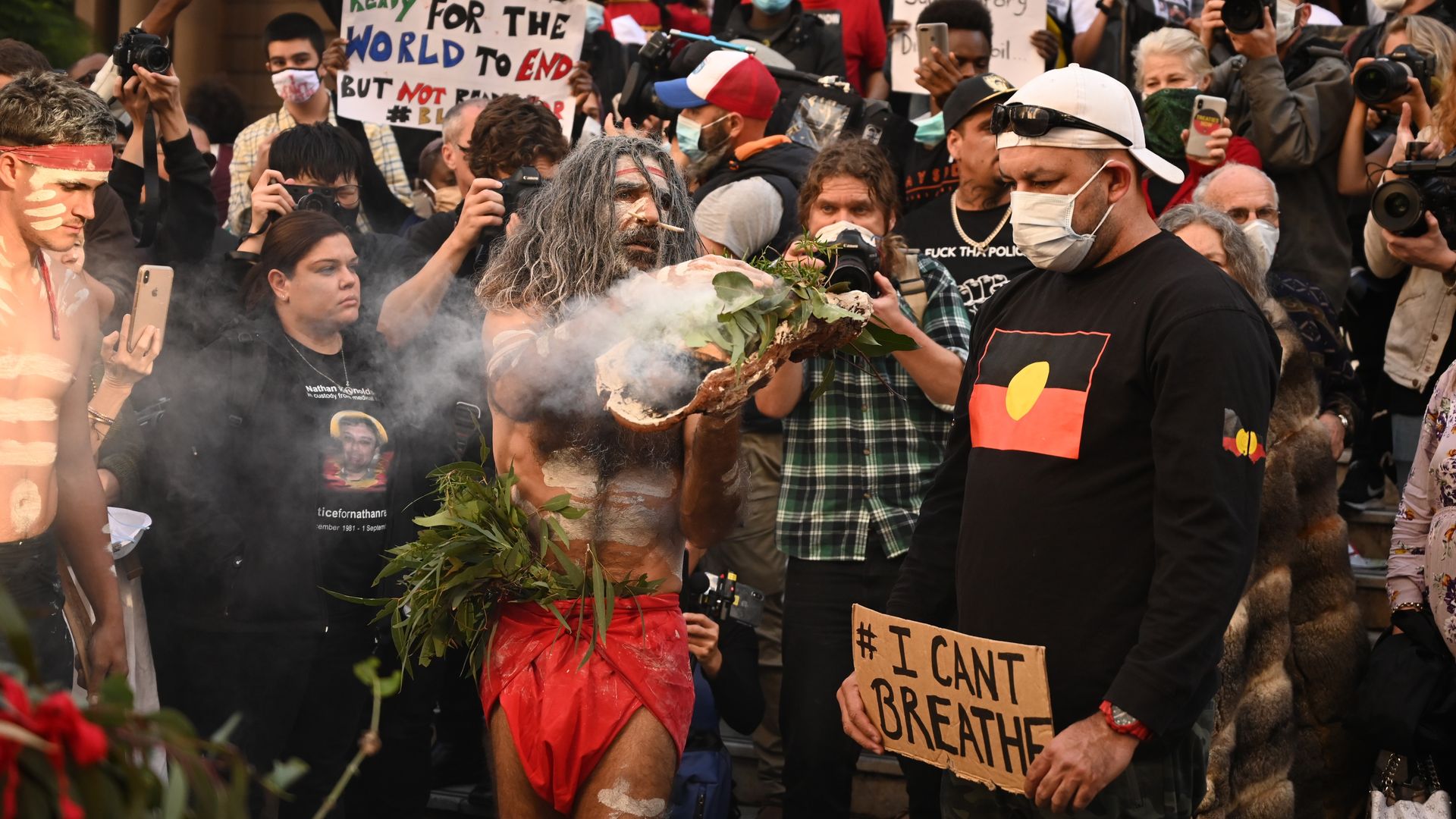 Aboriginal protesters perform a traditional smoking ceremony before the start of a Black Lives Matter demonstration