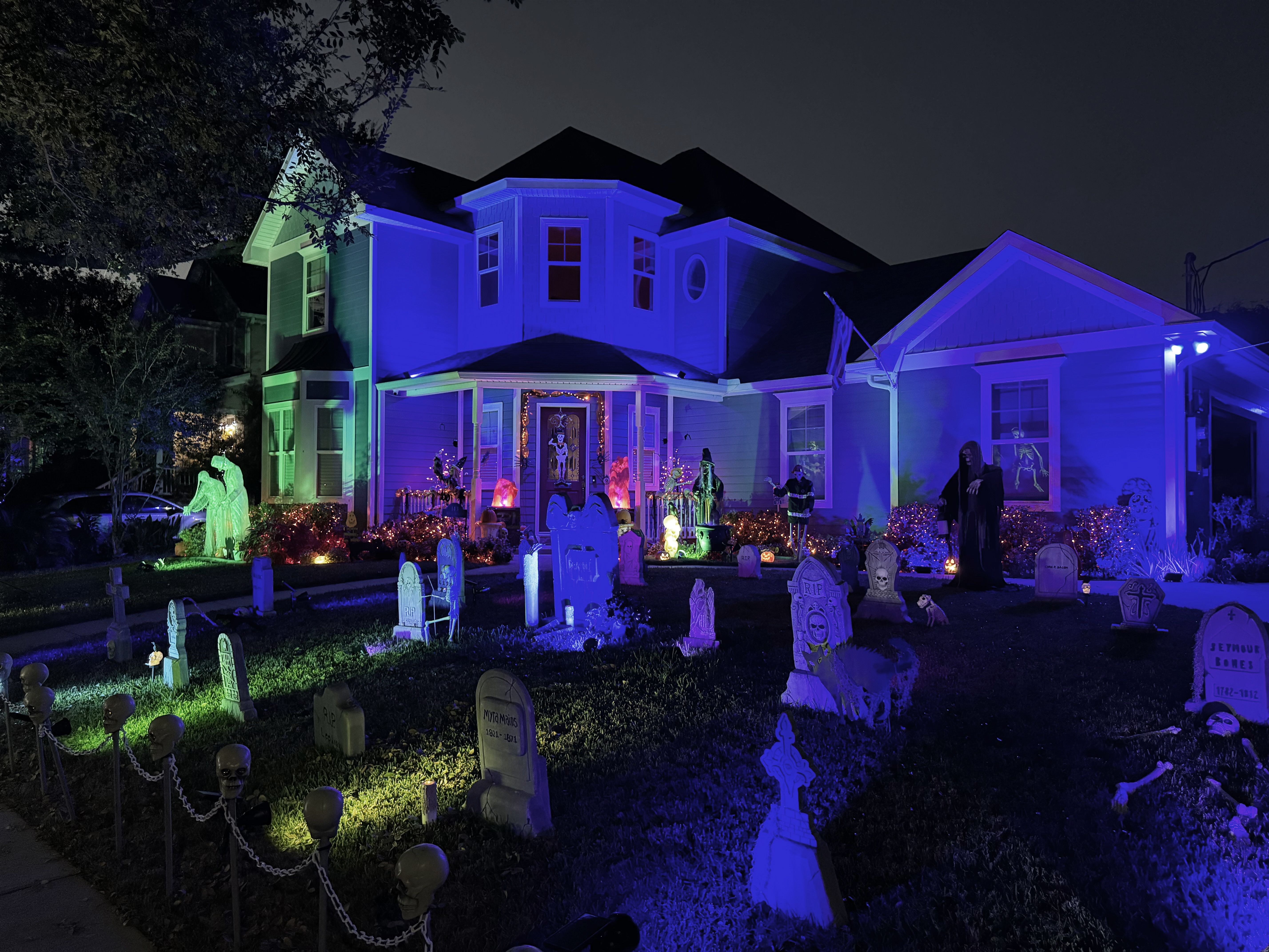 Photo shows a house with gravestones in the front.