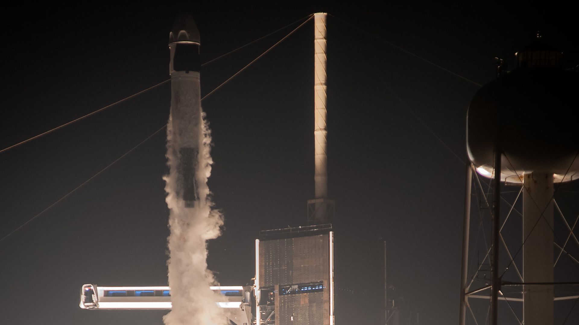 A Falcon 9 rocket taking off in the pitch dark night