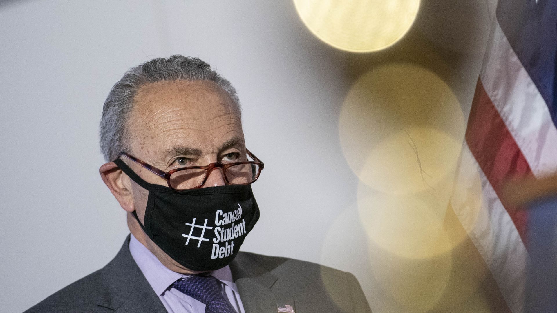 Photo of Chuck Schumer wearing a face mask that says "#Cancel Student Debt"
