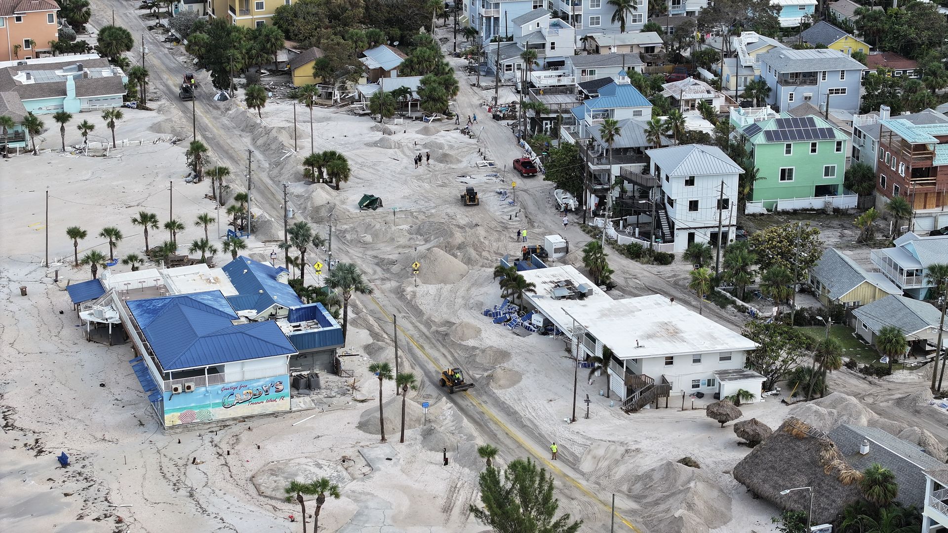 An overhead image of several homes and business buried in sand and debris.