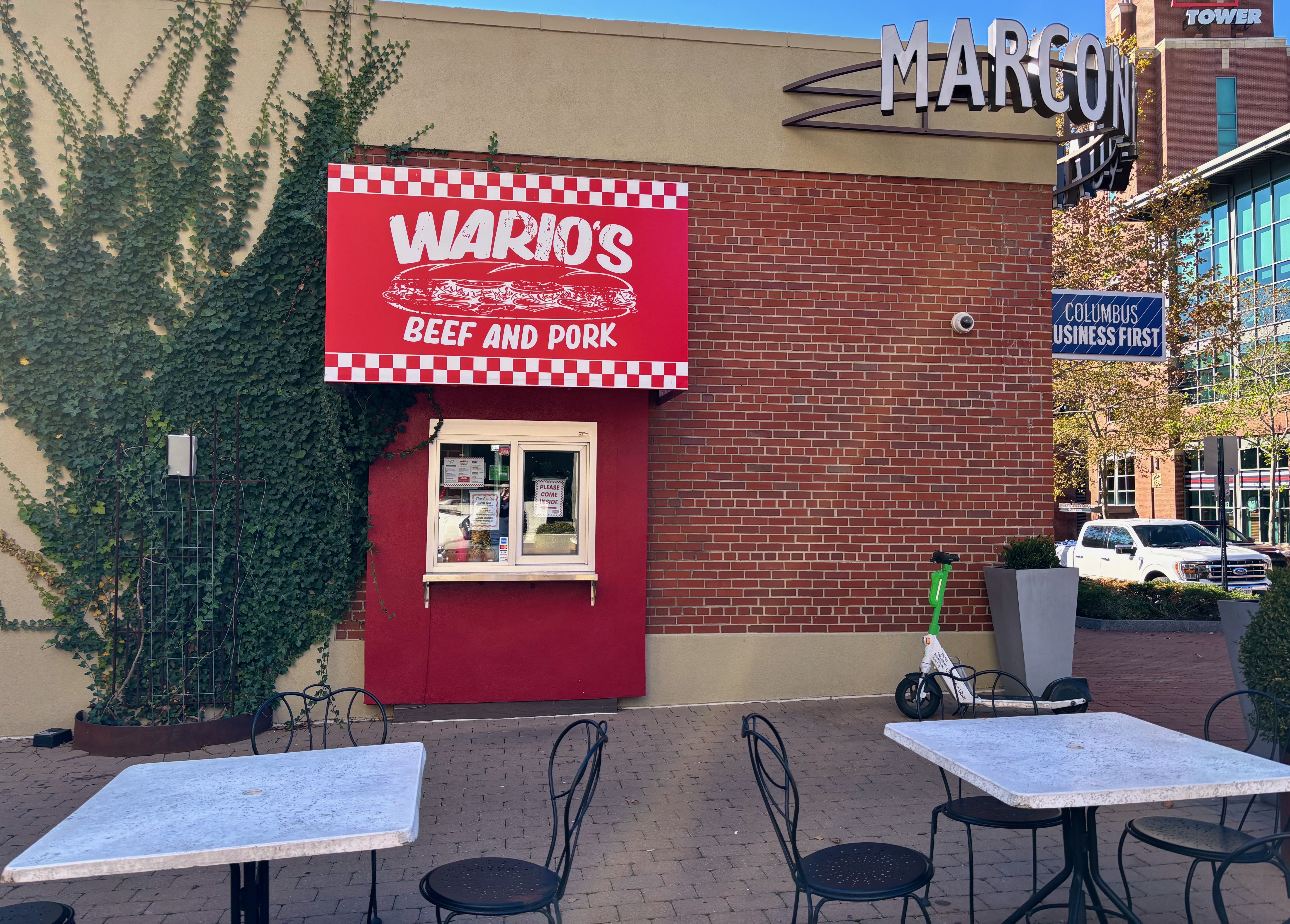The outside of Wario's walk-up window in a brick building, with a red awning that reads "Wario's Beef and Pork"