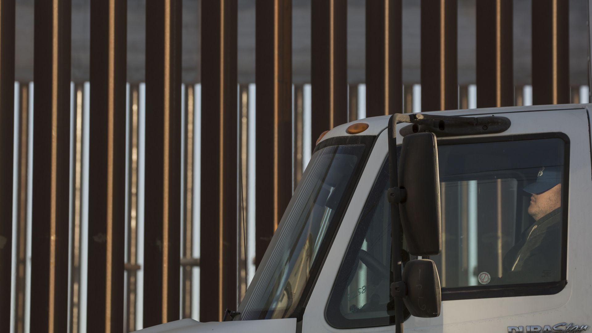A truck in front of the border wall.