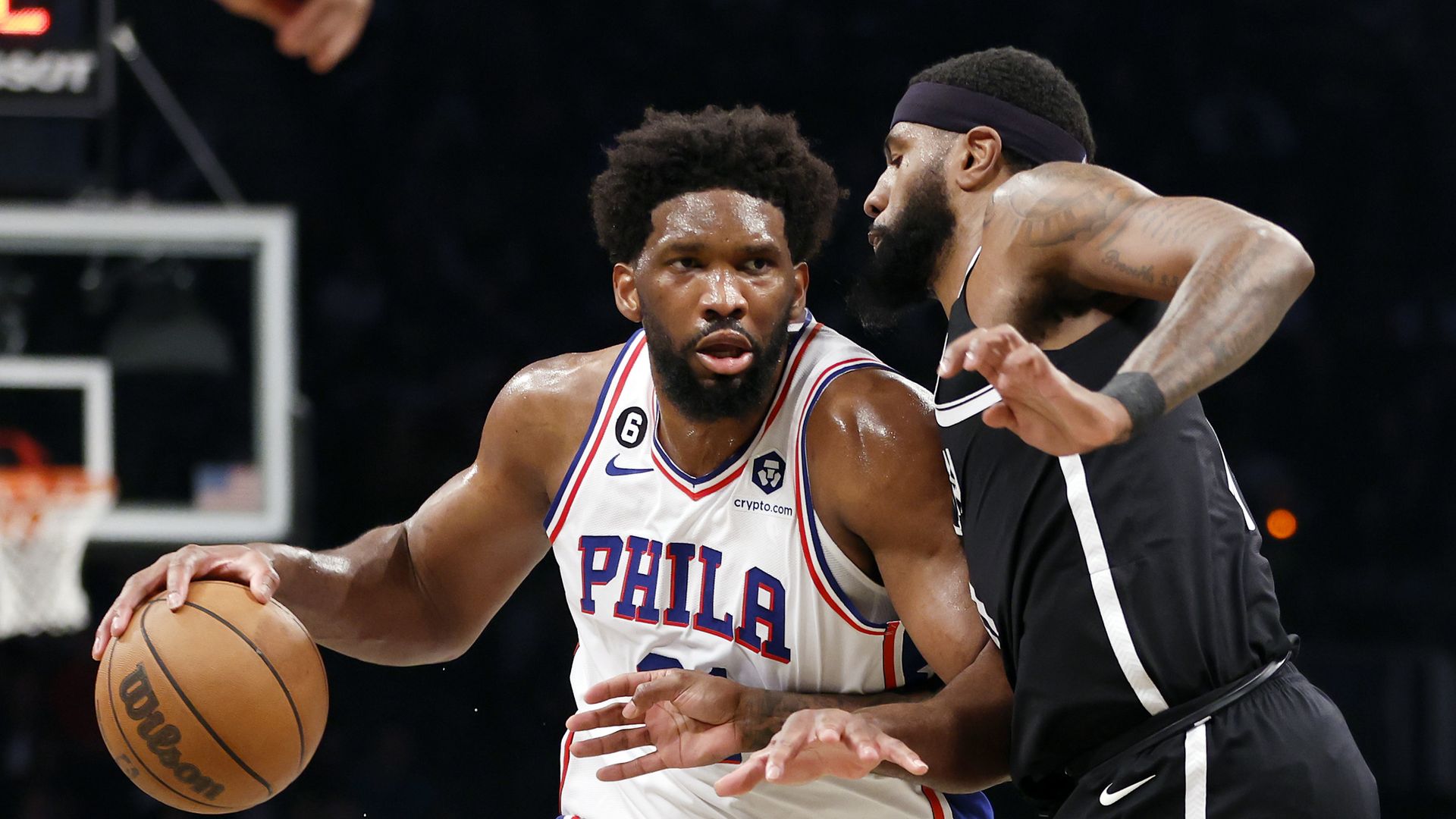 Sixers center Joel Embiid backs down the Nets' Royce O'Neale.
