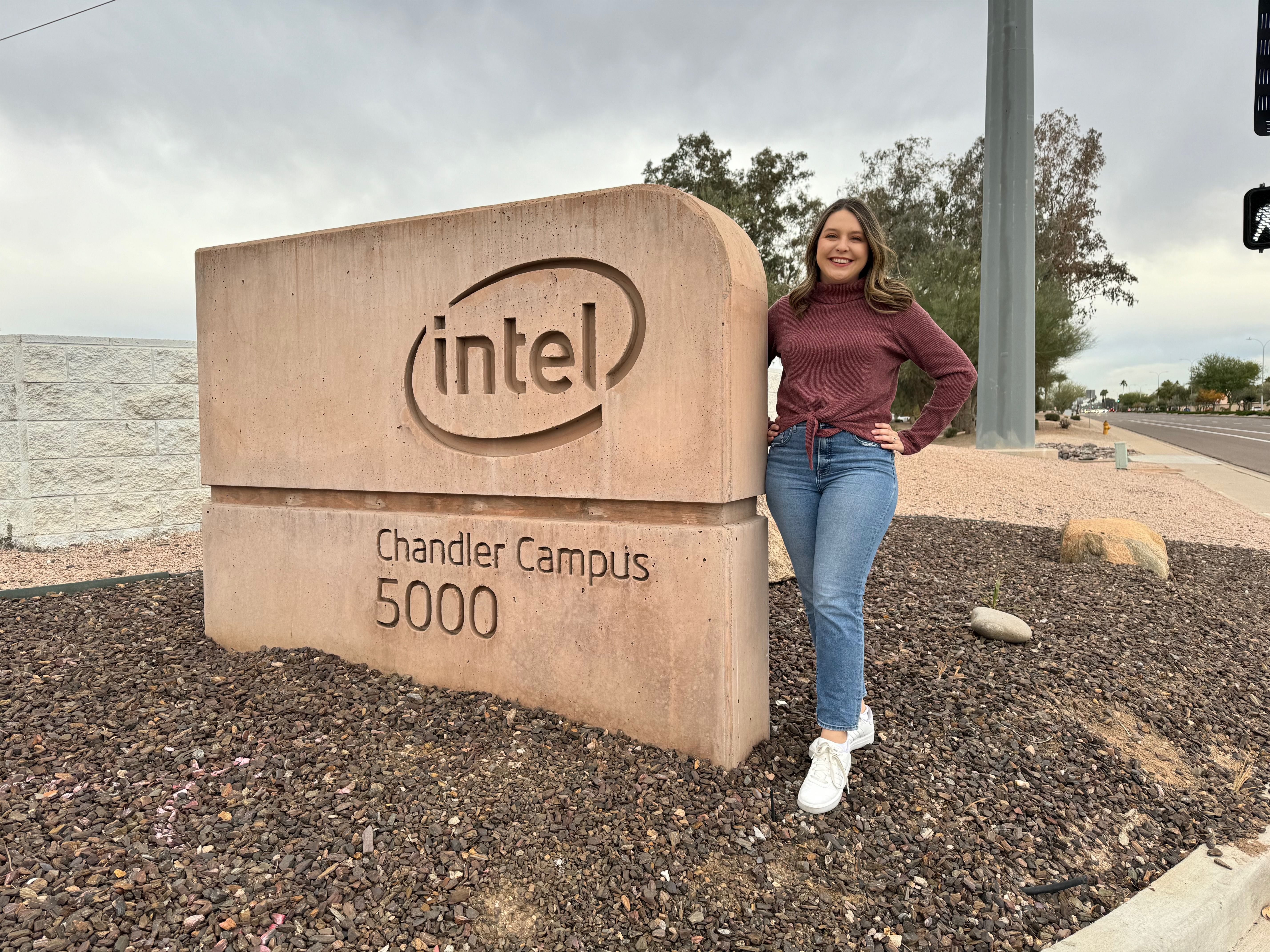 Axios Phoenix reporter Jessica Boehm stands next to a sign that says "Intel Chandler Campus"