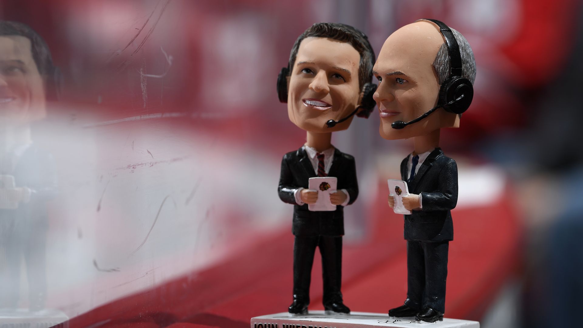 Photo of a bobblehead of two broadcasters. 