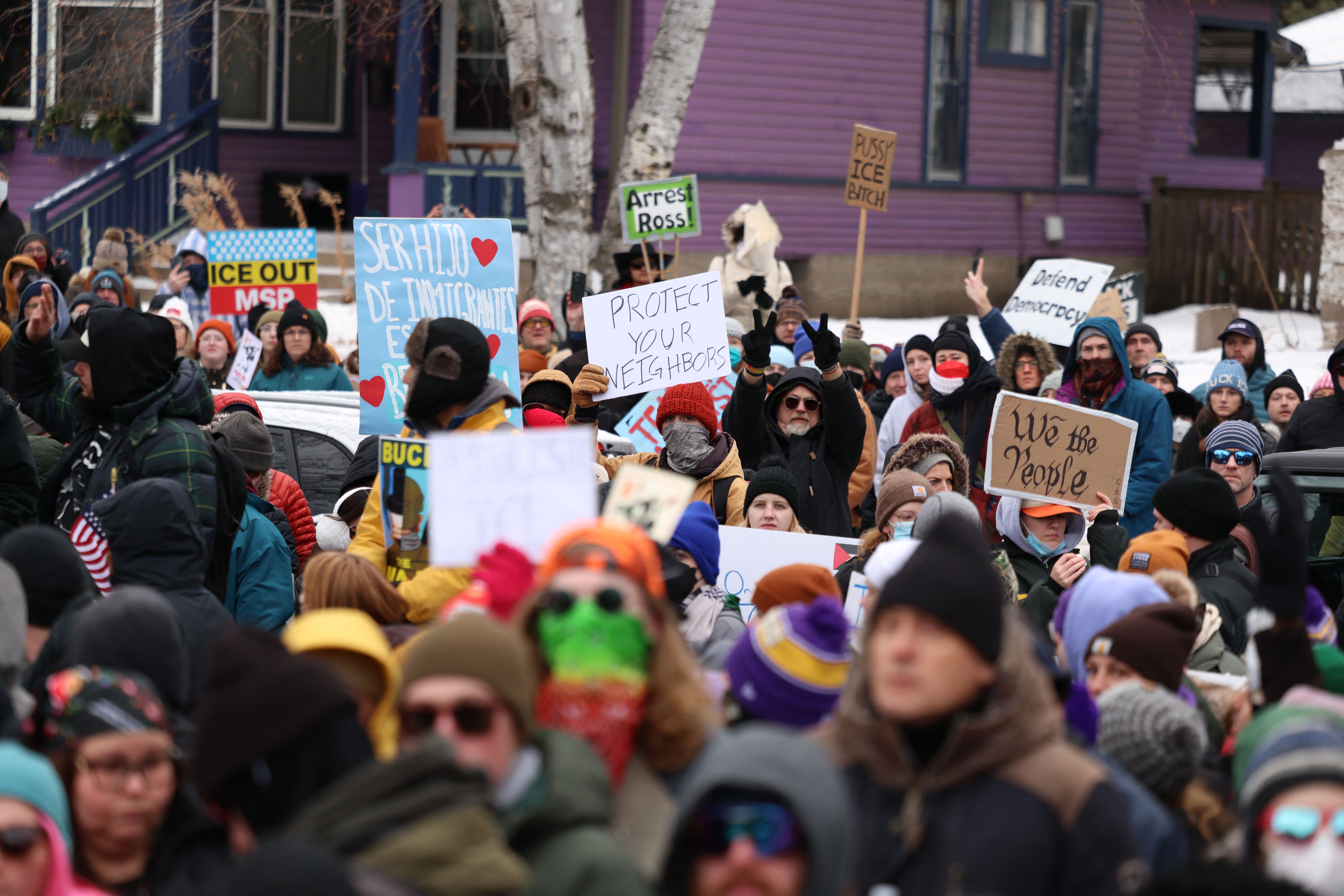 Protesters in front of purple building