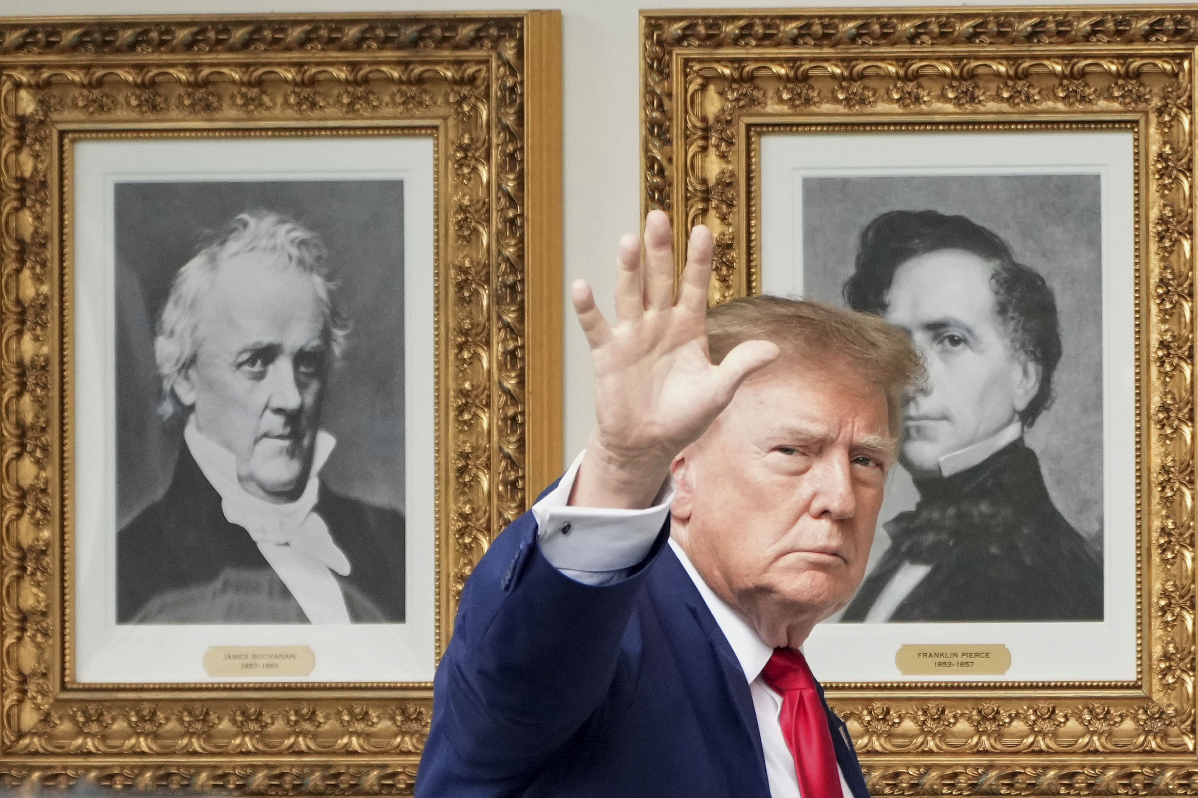 President Donald Trump waves as he walks past presidential portraits along the Colonnade before departing the White House, Friday, Oct. 16, 2026, in Washington. (AP Photo/Jacquelyn Martin)