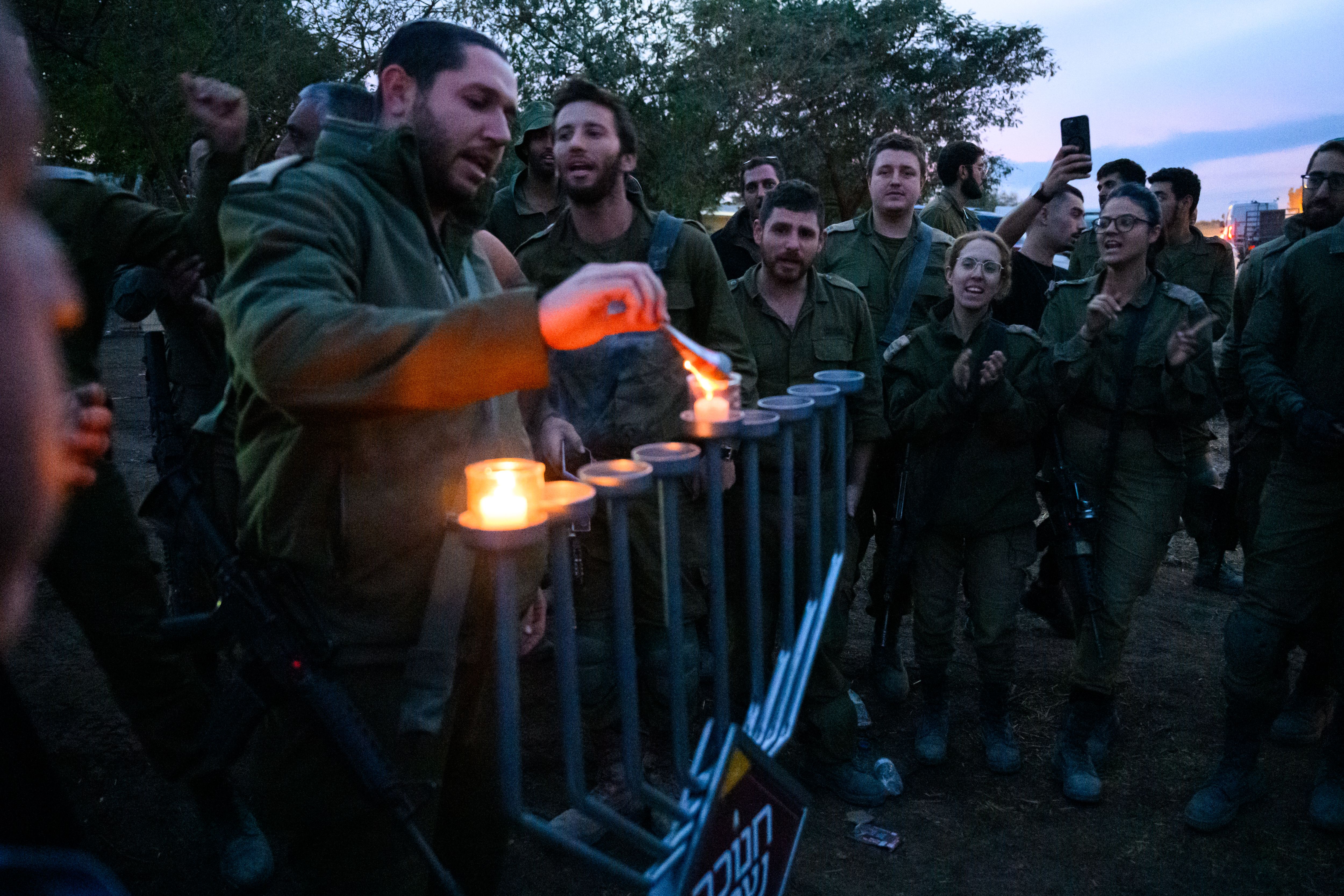  IDF soldiers light Hanukkah candles on the first night of Hanukkah near the Gaza border in Southern Israel.