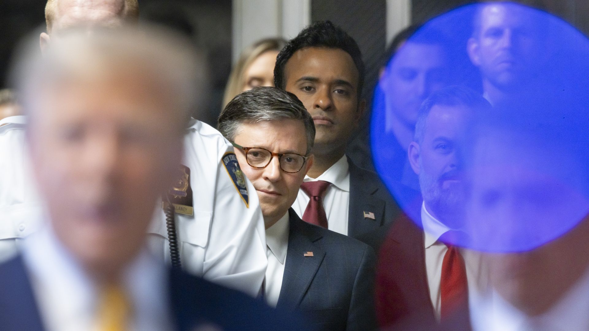 Speaker of the House Mike Johnson (C) and businessman Vivek Ramaswamy (3-L) listen as former U.S. President Donald Trump (Bottom-L) talks with reporters as he arrives for his trial for allegedly covering up hush money payments linked to an extramarital affair with Stormy Daniels